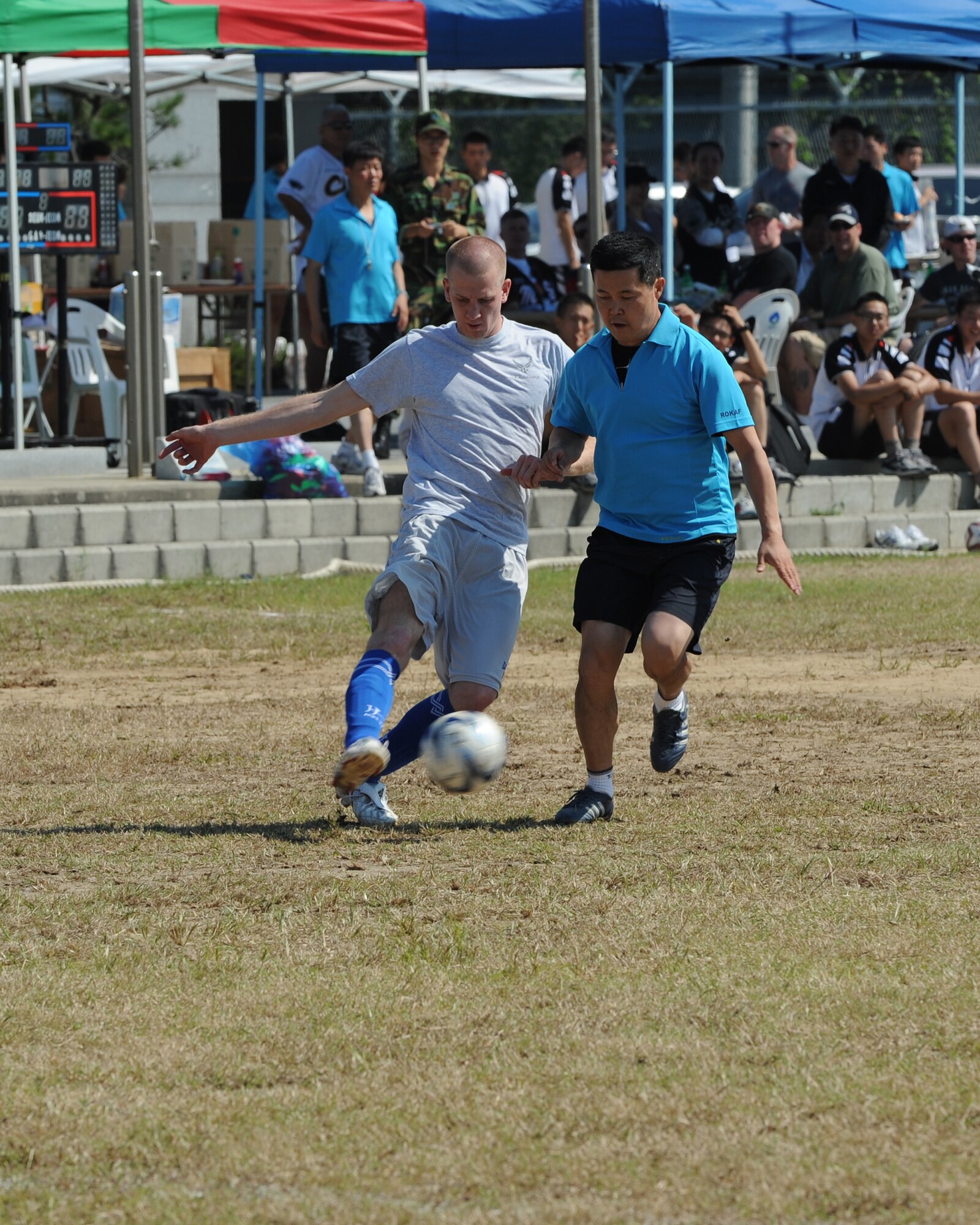 A member  of the United States Air Force commanders team tries to kick a soccer ball past a Republic of Korea Air Force commanders team defender during 2012 Kunsan Olympics USAF commanders versus RoKAF commanders soccer match on Kunsan Air Base, Republic of Korea, Sept. 20, 2012. The match featured teams made up of primarily wing, group and squadron level commanders and was a friendly competition between the two Air Forces. The RoKAF won the 20 minute match two to one. (U.S. Air Force photo/Staff Sgt. Jonathan Fowler)
