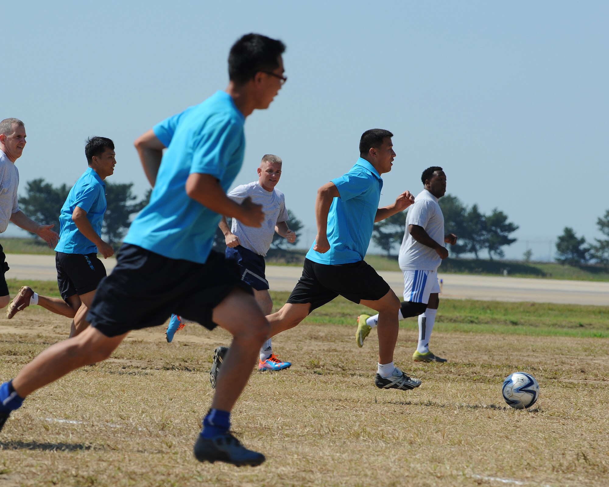 Members of the Republic of Korea and United States Air Forces commanders teams chase after a soccer ball during the 2012 Kunsan Olympics on Kunsan Air Base, RoK, Sept. 20, 2012. The match featured teams made up of primarily wing, group and squadron level commanders and was a friendly competition between the two Air Forces. The RoKAF won the 20-minute match two to one. (U.S. Air Force photo/Staff Sgt. Jonathan Fowler)