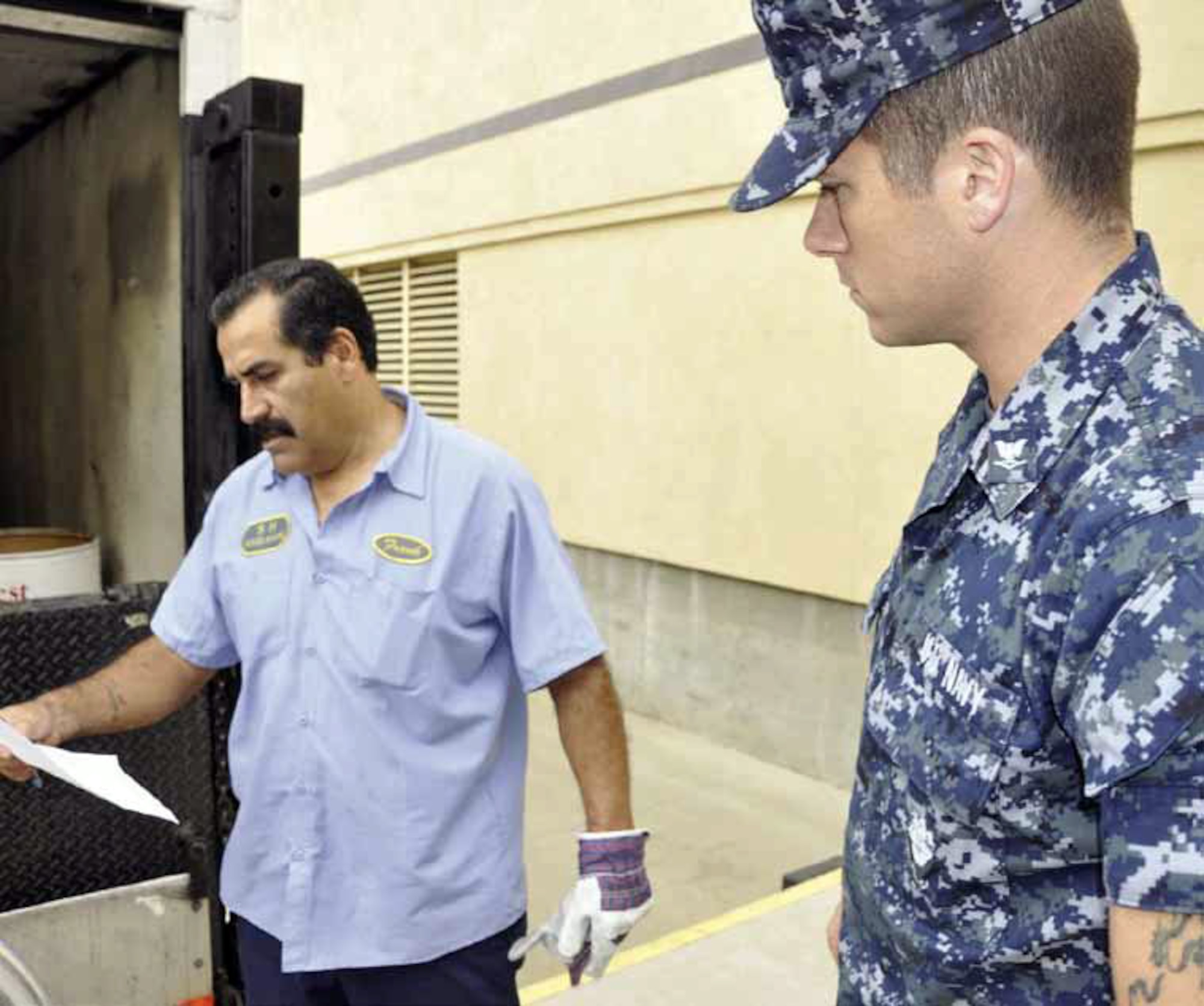 Navy Petty Officer Will Gaskill reviews the receipt for a food collection barrel with
Frank Felix, a delivery driver for Second Harvest Food Bank, at the loading dock at
American Forces Network Broadcast Center. The broadcast center took part in the
annual “Feds Feed Families” campaign, where government employers, military and
civilians, donate food items to their local communities through food banks. (DOD photo by Senior Chief Mass Communication Specialist John Harrington)