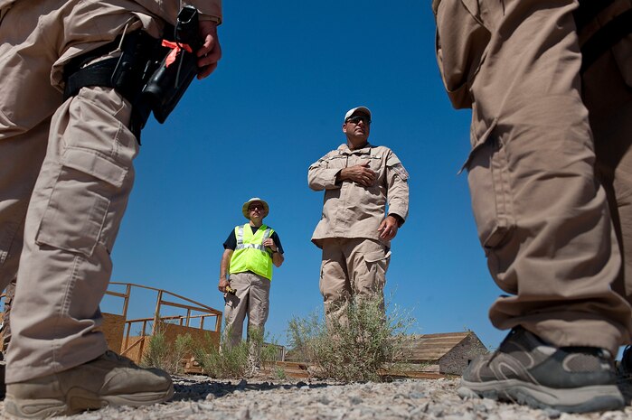 Marcus Custer, Homeland Security Investigations special agent, instructs other HSI special agents, during the Rapid Response Team Field Familiarization and Disaster Response Training exercise Sept. 20, 2012, at Nellis Air Force Base, Nev. HSI special agents chose Nellis AFB for the training location because of its ideal facilities, equipment, and military support, as well as its challenging terrain and climate. (U.S. Air Force photo by Staff Sgt. Christopher Hubenthal)