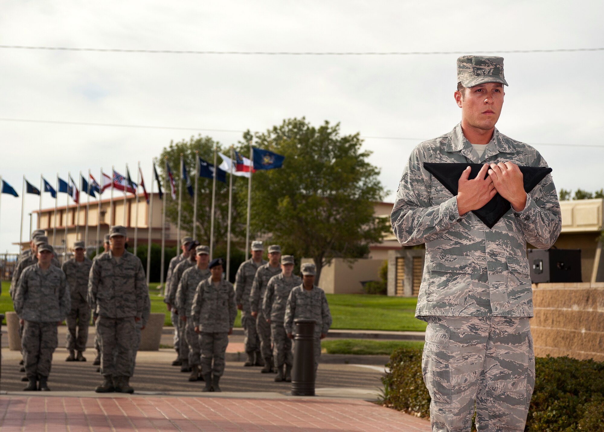 Airman 1st Class Roy Ybarra, 412th Aircraft Maintenance Squadron, holds the POW/MIA Flag after it was lowered from the flagpole in front of Bldg. 1 and folded during the annual POW/MIA Recognition Day Retreat Ceremony Sept. 21.  (U.S. Air Force photo by Ethan Wagner)