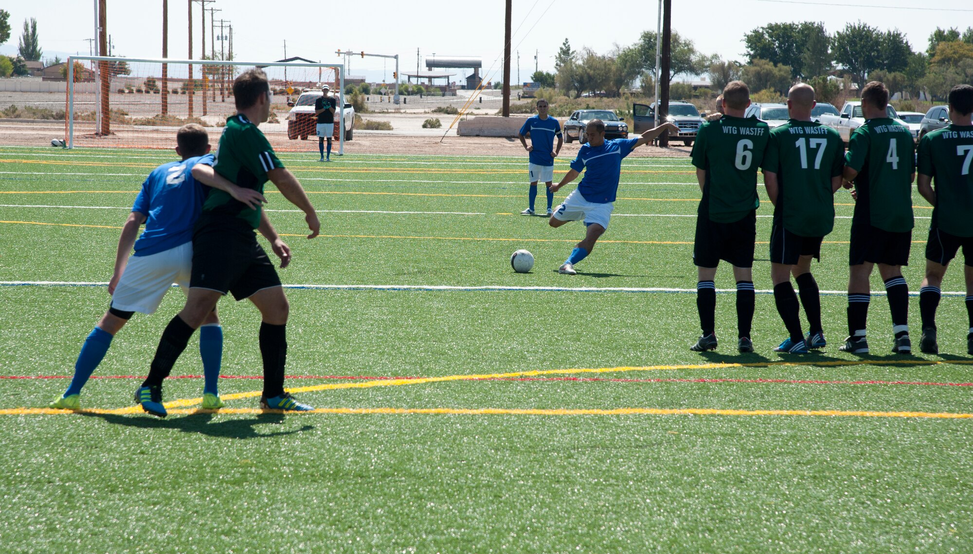 A member of the U.S. Air Force Holloman AFB soccer team takes a free kick against the German Air Force Flying Training Center defenders during the 3rd annual Oktobercup Sept. 22, at the Holloman Air Force, N.M., soccer complex. The international soccer game between the U.S. Air Force Holloman AFB team and GAF was the opening event to the Oktoberfest activities which ensued later that evening. The GAF won the game 4 to 0. (U.S. Air Force photo by Airman 1st Class Colin Cates/Released)