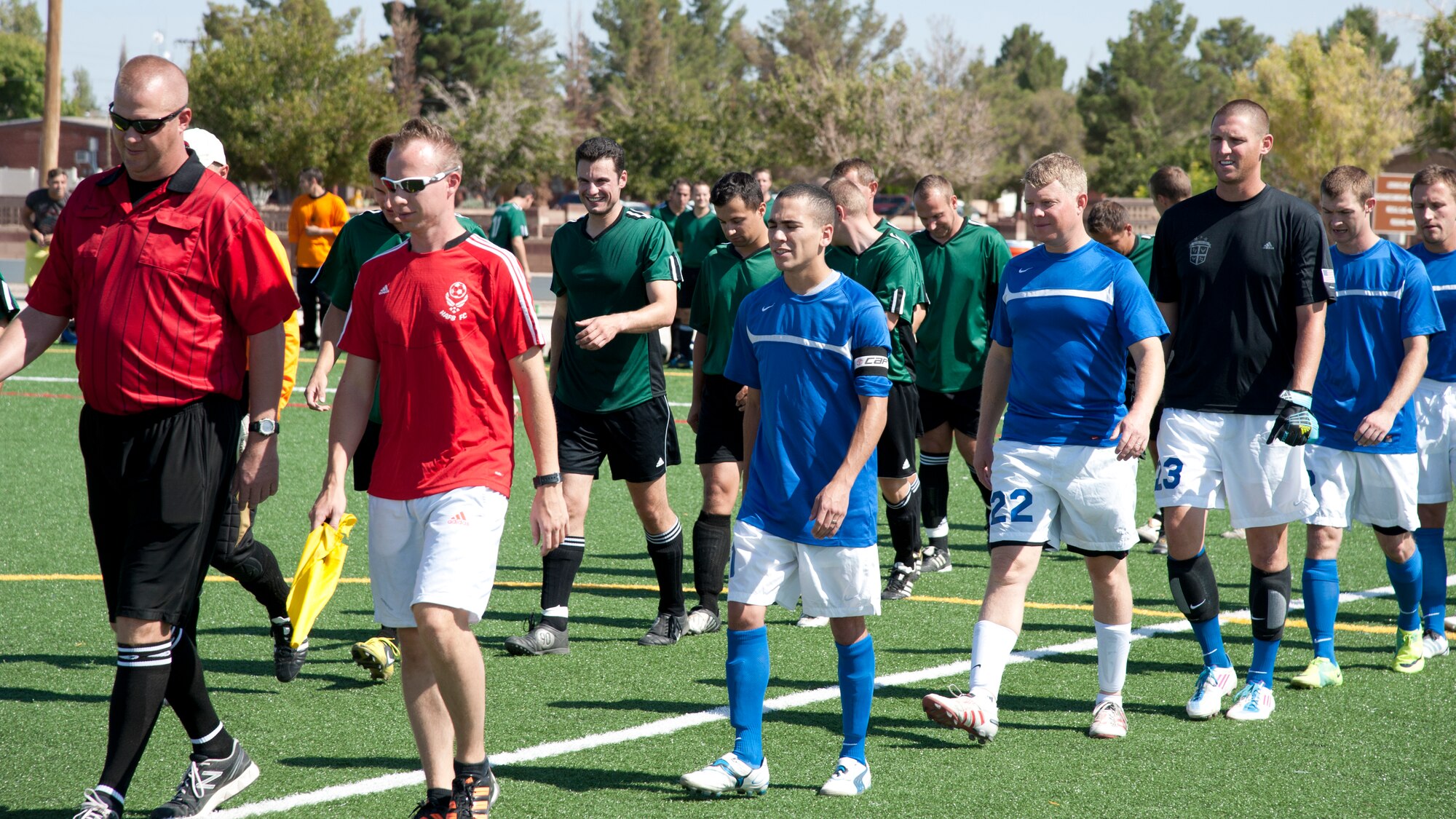 Members from the U.S. Holloman AFB and German Air Force soccer teams walk to midfield to shake hands and take their positions for the start of the 3rd annual Oktobercup Sept. 22, at the Holloman Air Force Base, N.M., soccer complex. Col. Andrew Croft, 49th Wing commander and Col. Armin Havenith, German Air Force Flying Training Center Commander agreed to a challenge to play an international soccer match between the U.S. Air Force Holloman AFB team and German Air Force Flying Training Center soccer team.  The GAF won the game 4 to 0. (U.S. Air Force photo by Airman 1st Class Colin Cates/Released)