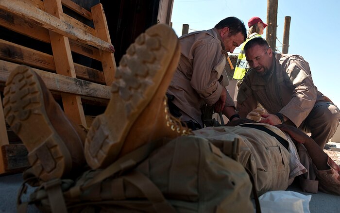 Austin Berrier and George Happ, Homeland Security Investigations special agents, provide medical care to a simulated casualty during the Rapid Response Team Field Familiarization and Disaster Response Training exercise Sept. 20, 2012, at Nellis Air Force Base, Nev. HSI special agents chose Nellis AFB for the training location because of its ideal facilities, equipment, and military support, as well as its challenging terrain and climate. (U.S. Air Force photo by Staff Sgt. Christopher Hubenthal)