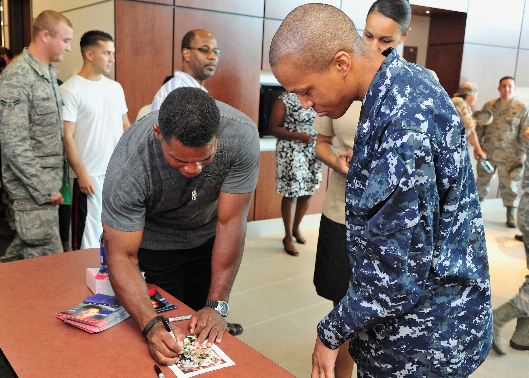 Herschel Walker, former NFL running back, signs memorabilia for Petty Officer 2nd class Marcus Jones, Navy Operational Support Center administrative clerk, at Luke Air Force Base, Ariz., Sept. 21, 2012. Walker visited Luke in partnership with The Freedom Care Program Anti-Stigma Campaign. (U.S. Air Force photo by Staff Sgt. Jason Colbert)
 
