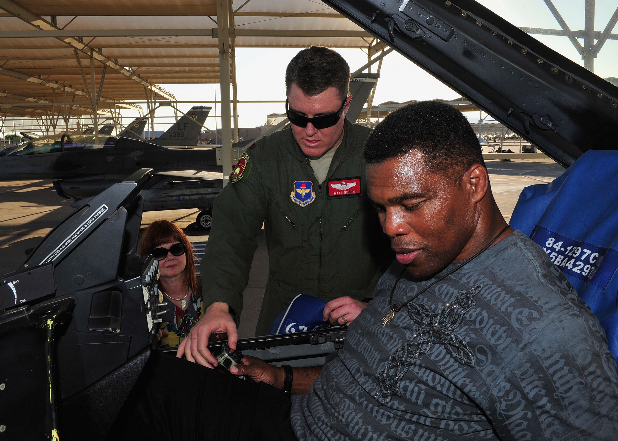 Herschel Walker, former NFL running back, sits in an F-16 Fighting Falcon while Maj. Matt Busch, 56th Training Squadron assistant director of operations, explains the controls of the aircraft at Luke Air Force Base, Ariz., Sept. 21, 2012. Walker visited Luke in partnership with The Freedom Care Program Anti-Stigma Campaign He spoke with members of the Luke community about his experiences and was treated to a flightline tour to culminate his visit. (U.S. Air Force photo by Staff Sgt. Jason Colbert)
 
 
