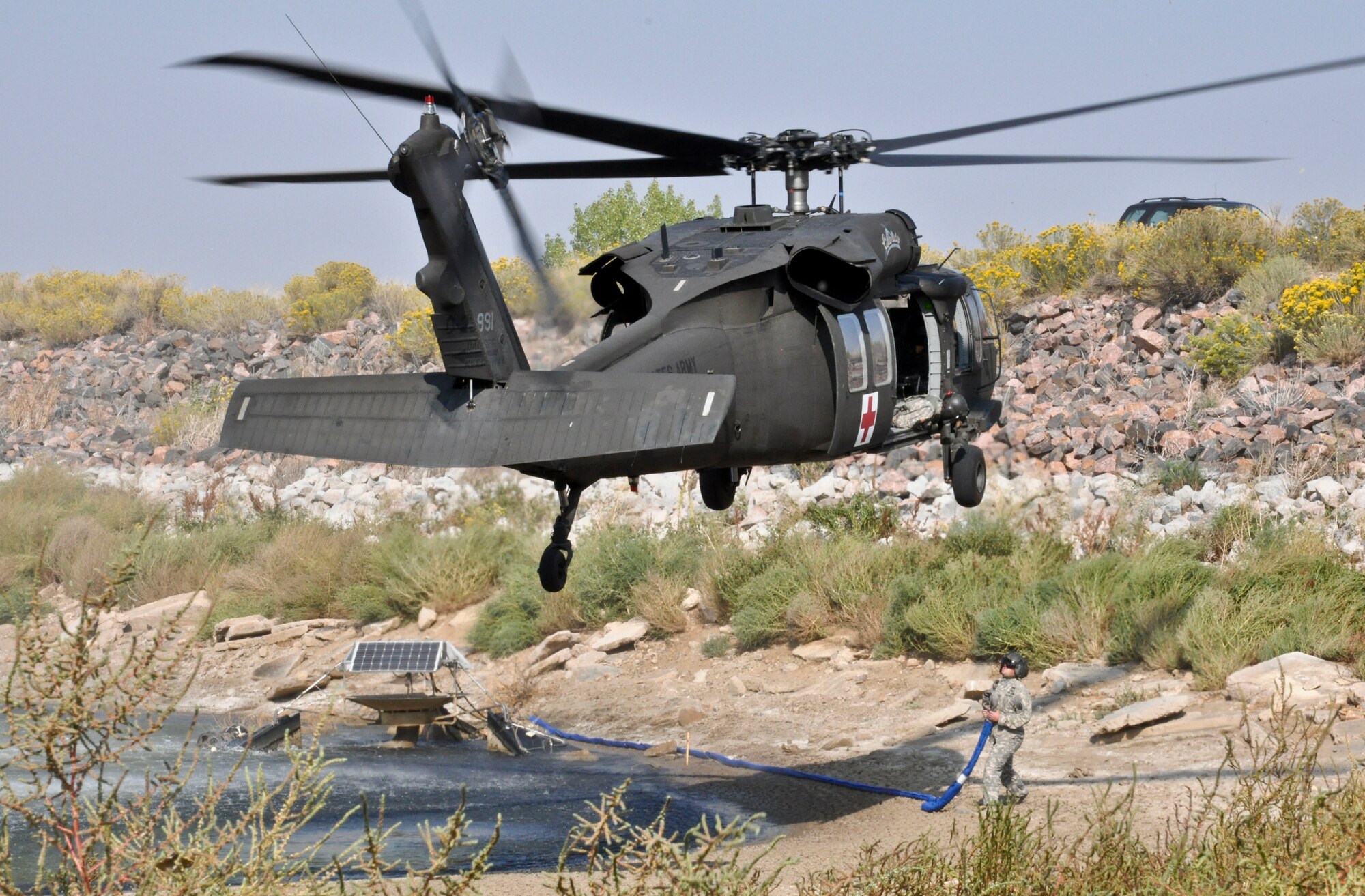 BUCKLEY AIR FORCE BASE, Colo. – A Colorado Army National Guard UH-60 Black Hawk helicopter prepares to connect the rigging required to lift a non-functioning aerator from Lake Williams Sept. 20, 2012. The 460th Civil Engineer Squadron biologist Krystal Phillips requested assistance from the COANG to lift the device from the lake. (U.S. Air Force photo by Staff Sgt. Nicholas Rau) 