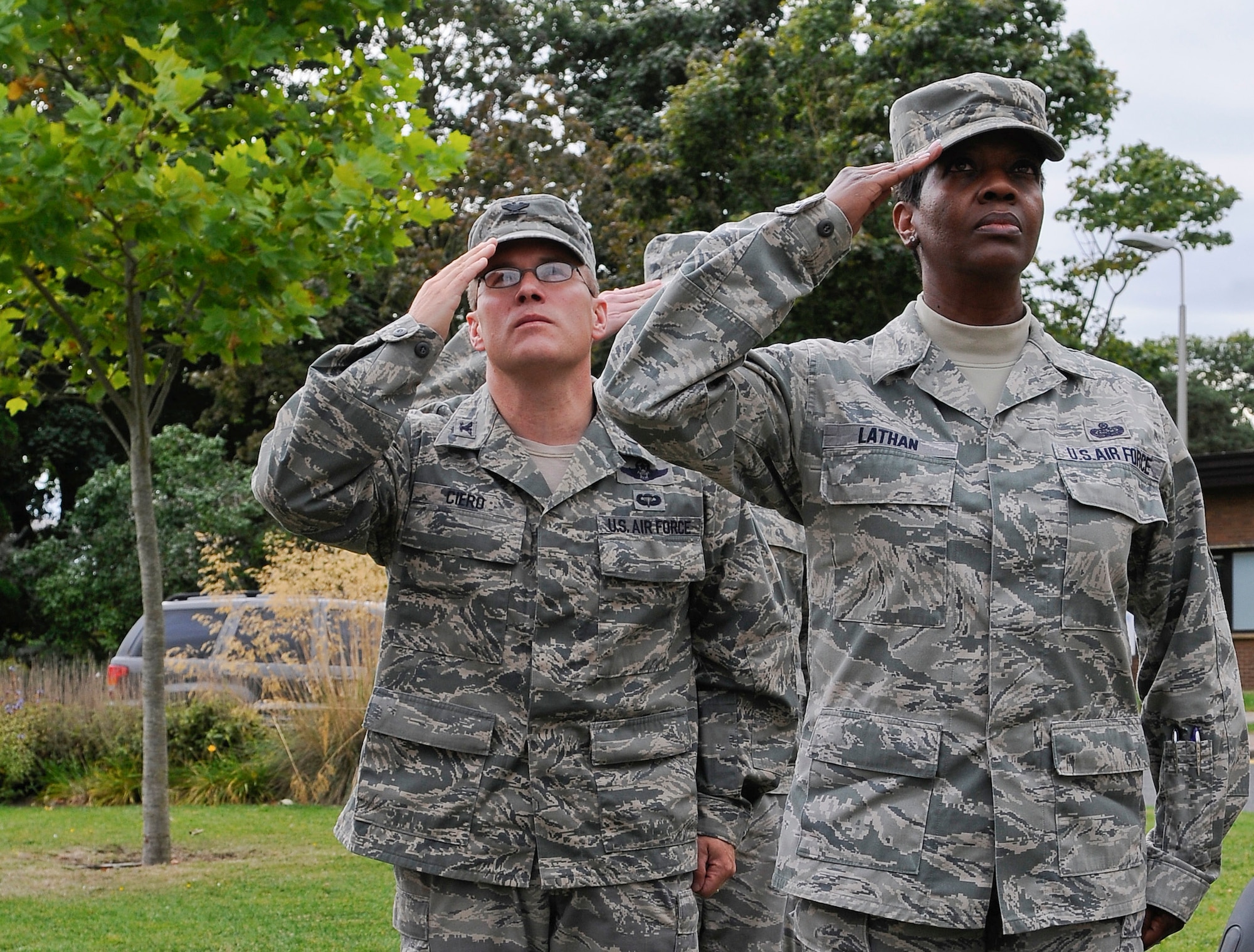 ROYAL AIR FORCE LAKENHEATH, England - Chief Master Sgt. SaRita Lathan (right), 48th Fighter Wing command chief, and Col. Mark Ciero, 48th FW vice commander, salute the U.K. and U.S. flags during the playing of the national anthems at the prisoners of war and missing in action 24-hour vigil Sept. 20, 2012. The vigil was one of many events observed on base during POW/MIA remembrance week to honor the sacrifices of those who served in the armed forces; those who were prisoners of war, and those who remain missing. (U.S. Air Force photo by Senior Airman Connor Estes)