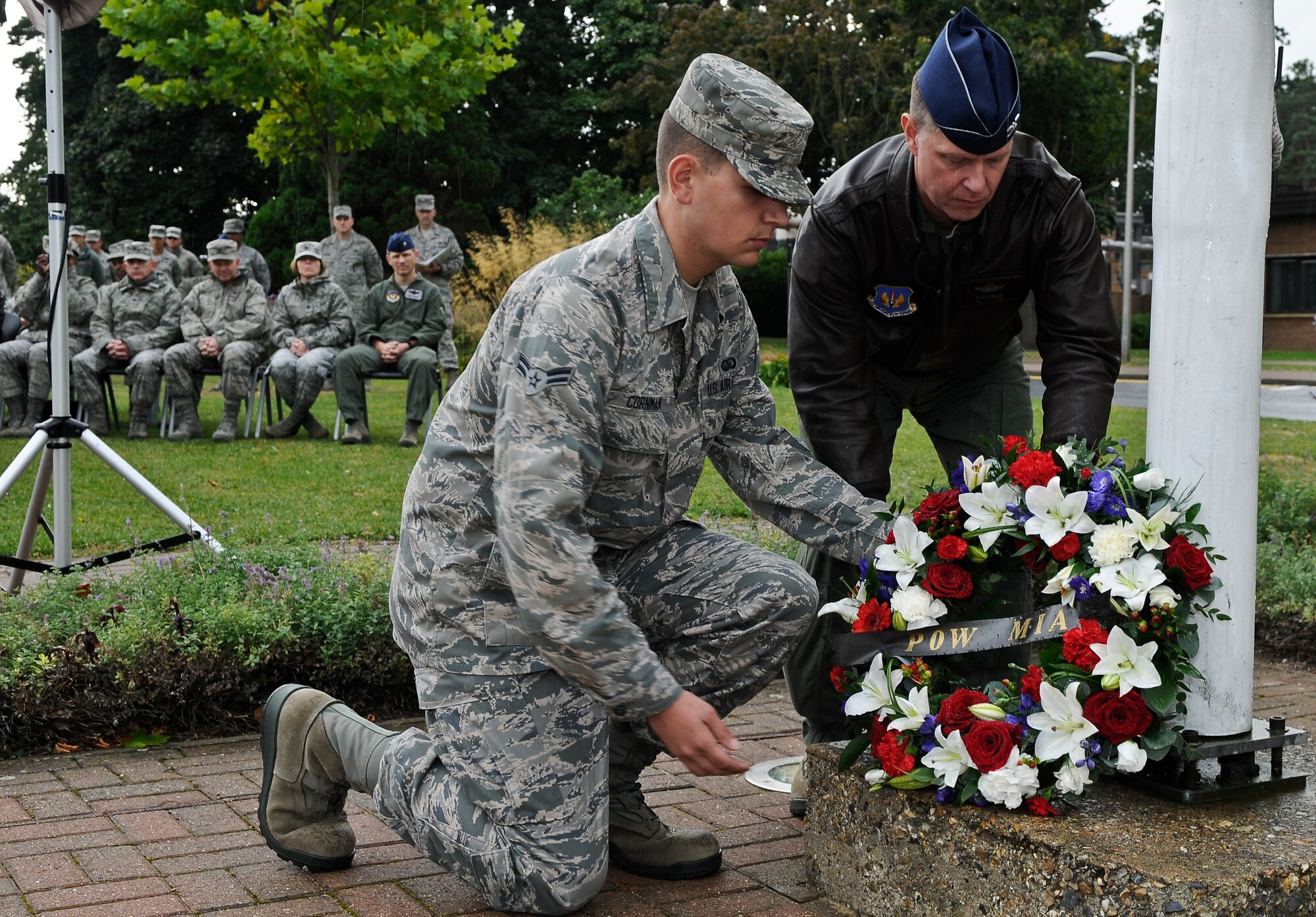 ROYAL AIR FORCE LAKENHEATH, England - Airman 1st Class Zachary Cornman (left), 48th Force Support Squadron customer service apprentice and Col. Kyle Robinson, 48th Fighter Wing commander, place a wreath at the base of the POW/MIA flag pole during a retreat ceremony Sept. 21, 2012. POW/MIA Remembrance Week concluded with the retreat ceremony to honor the sacrifices of those who served in the armed forces; those who were prisoners of war, and those who remain missing. (U.S. Air Force photo by Senior Airman Connor Estes)