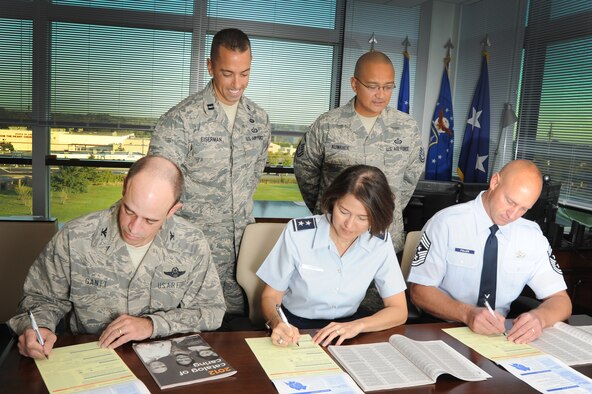 (Left to right), Air Force District of Washington Vice Commander Col. Michael E. Gantt, AFDW Commander Maj. Gen. Sharon K.G. Dunbar and AFDW Command Chief Master Sgt. Scott A. Fuller sign their Combine Federal Campaign contribution forms as Capt. Chase Eiserman and Master Sgt. Frank Kuwanoe, AFDW CFC coordinators, assist Sept. 21 on Joint Base Andrews, Md. AFDW kicked off the 2012 CFC Oct. 1 with a goal of $348,500. (U.S. Air Force photo by Senior Airman Tabitha N. Haynes) 