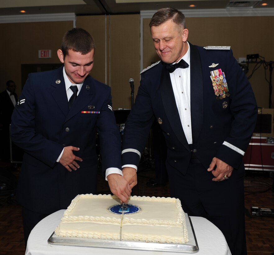 U.S. Air Force Airman 1st Class Austin Harvill, 633rd Air Base Wing Public Affairs journalist, and Lt. Gen. Frank Gorenc, Air Staff, Headquarters U.S. Air Force assistant Vice Chief of Staff and Director, cut the cake at the Air Force Ball in Newport News, Va., Sept. 22, 2012. Traditionally, the lowest and the highest ranking Airmen in attendance cut the cake together. (U.S. Air Force photo by Airman 1st Class Teresa Aber/Released)