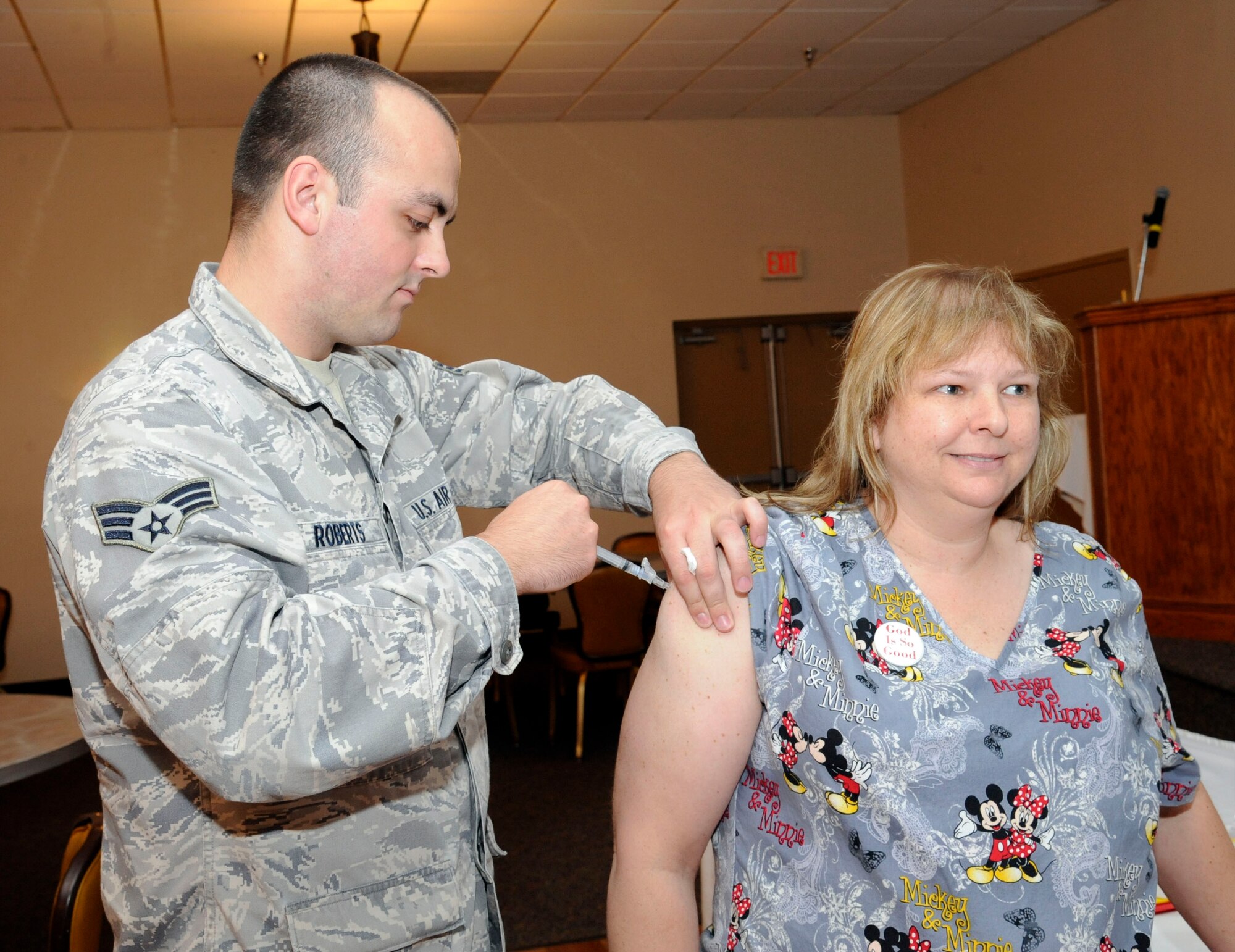 Donna Vanarsdall, 2nd Medical Group immunization clinic, receives an injection the of flu vaccine from Senior Airman Alexander Roberts, 2 MDG immunization clinic, on Barksdale Air Force Base, La., Sept. 24. Normally the vaccines are given as a nasal mist spray, but certain individuals get a traditional needle depending on various factors. (U.S. Air Force photo/Airman 1st Class Andrew Moua)(RELEASED)