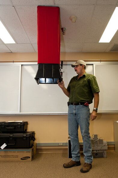Jerry Riley, Headquarters Air Force Civil Engineer Support Agency heating, venting and air conditioning equipment specialist, checks the air flow of a room in Building 7450 during an inspection at Ellsworth Air Force Base, S.D., Sept. 19, 2012. Riley travels around the world to inspect Air Force facilities for proper airflow and energy efficiency. Insufficient airflow can lead to a build up of carbon monoxide, causing an unhealthy work environment. (U.S. Air Force photo by Airman 1st Class Kate Thornton-Maurer/Released)