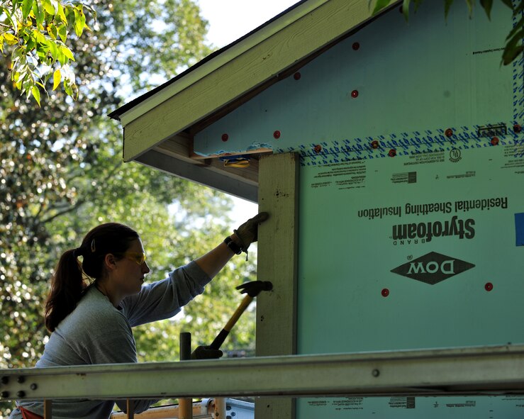 Emily Kukurda, 71st Rescue Squadron navigator, attaches a piece of lumber to a house, which is being built by volunteers for Habitat for Humanity, in Valdosta, Ga., Sept. 21, 2012. More than 100 volunteers helped build the house. (U.S. Air Force photo by Stephanie Mancha/Released)
