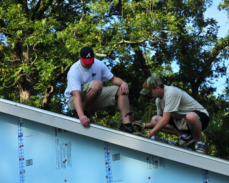 Matthew Bates, right, and Danson Hensley, 23d Civil Engineer Squadron firefighters, hammer shingles on the roof of a house in Valdosta, Ga., Sept. 21, 2012. Members from Team Moody volunteered to help Habitat for Humanity build a house for a family of three. (U.S. Air Force photo by Stephanie Mancha/Released)

