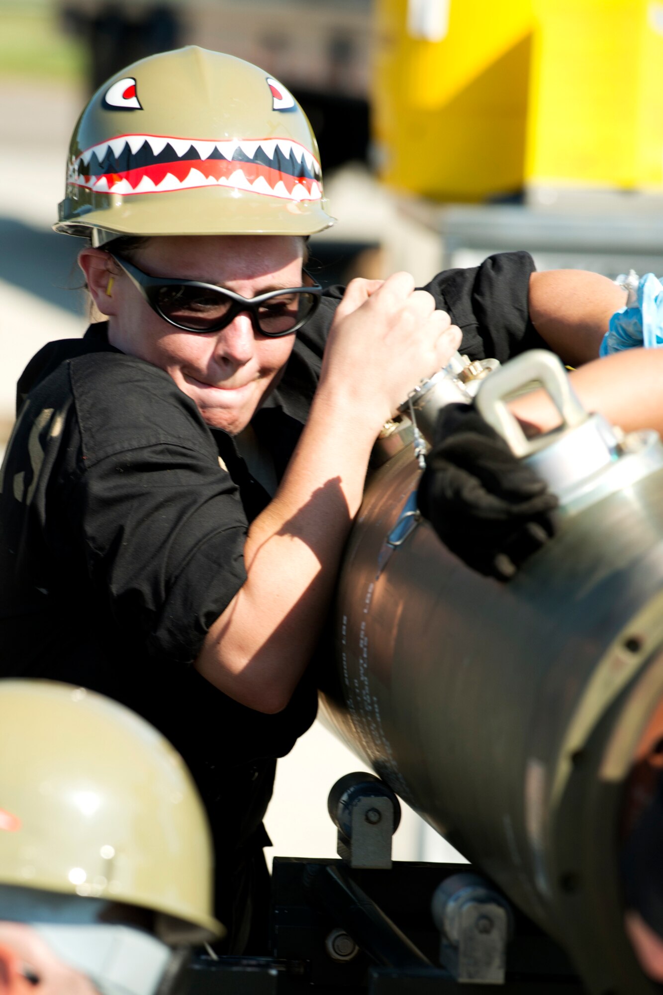 U.S. Air Force Senior Airman Teresa Procell, 307th Maintenance Squadron munitions technician, strains to hold on to a 2000 pound Joint Direct Attack Munitions (JDAM) during the Global Strike Challenge competition, Sept. 13, 2012, Barksdale Air Force Base, La. The munitions team was tasked to successfully build 16 JDAMs. (U.S. Air Force photo by Master Sgt. Greg Steele/Released)