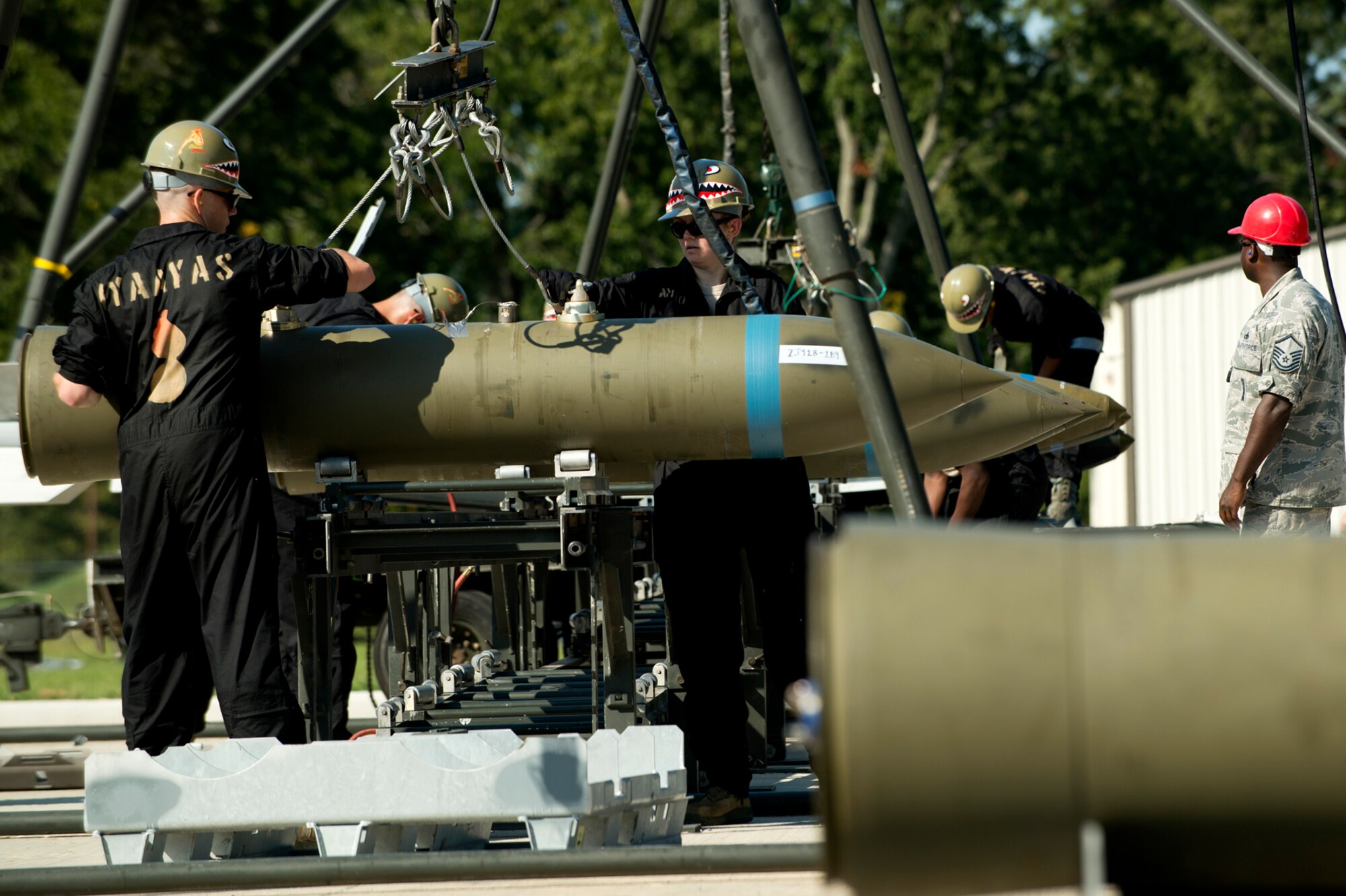 Munitions technicians assigned to the 307th Maintenance Squadron load  a 2000 pound general purpose bomb onto the assembly rack during a bomb build competition for the Global Strike Challenge, Sept. 13, 2012, Barksdale Air Force Base, La. The munitions team was tasked with building 16 Joint Direct Attack Munitions during the timed event. (U.S. Air Force photo by Master Sgt. Greg Steele/Released)