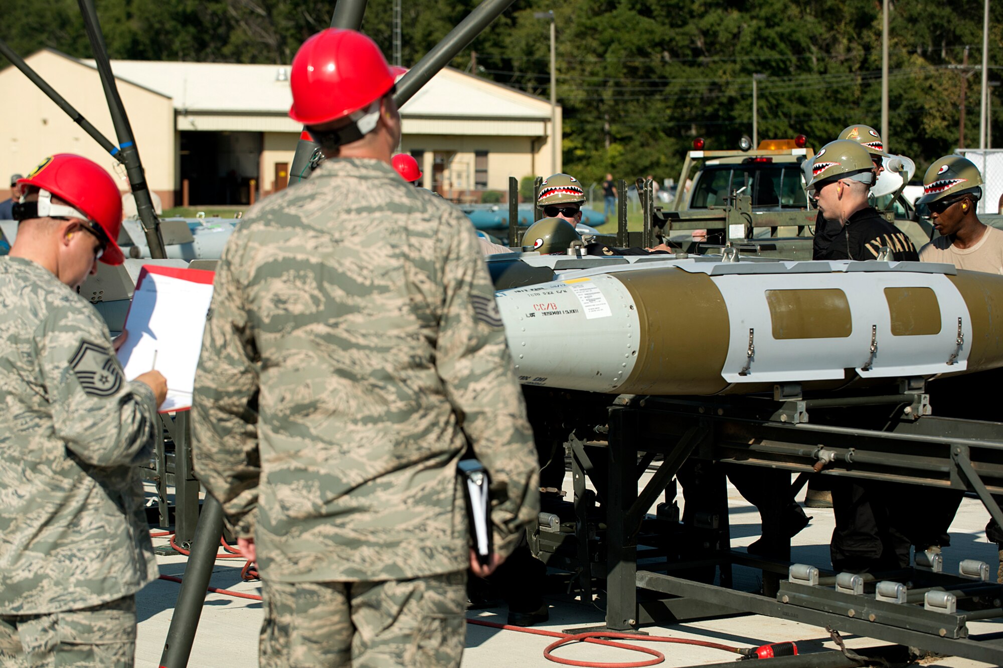An evaluator takes notes during a bomb build competition during the Global Strike Challenge, Sept. 13, 2012, Barksdale Air Force Base, La. Munitions technicians assigned to the 307th Maintenance Squadron participated in the timed event and were tasked with building 16, 2000 pound Joint Direct Attack Munitions. (U.S. Air Force photo by Master Sgt. Greg Steele/Released)