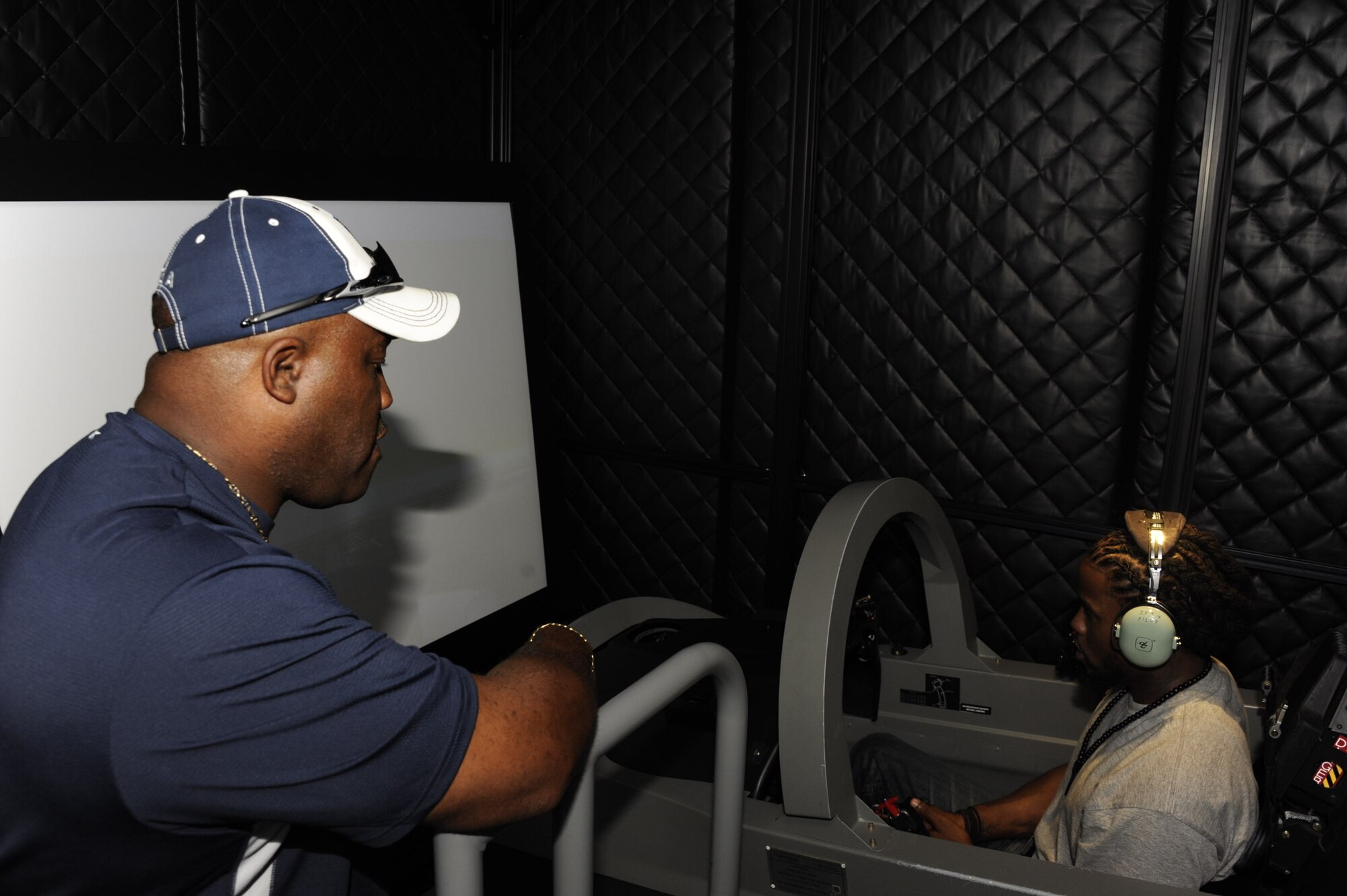 Former NFL players Daryll Brown and Kevin O'Neal familiarize themselves with a simulator during their tour of the 80th Flying Training Wing.  The two were at Sheppard for the 82nd Mission Support Group's celebrity golf tournament on September 21st. (U.S. Air Force Photo/Danny Webb)