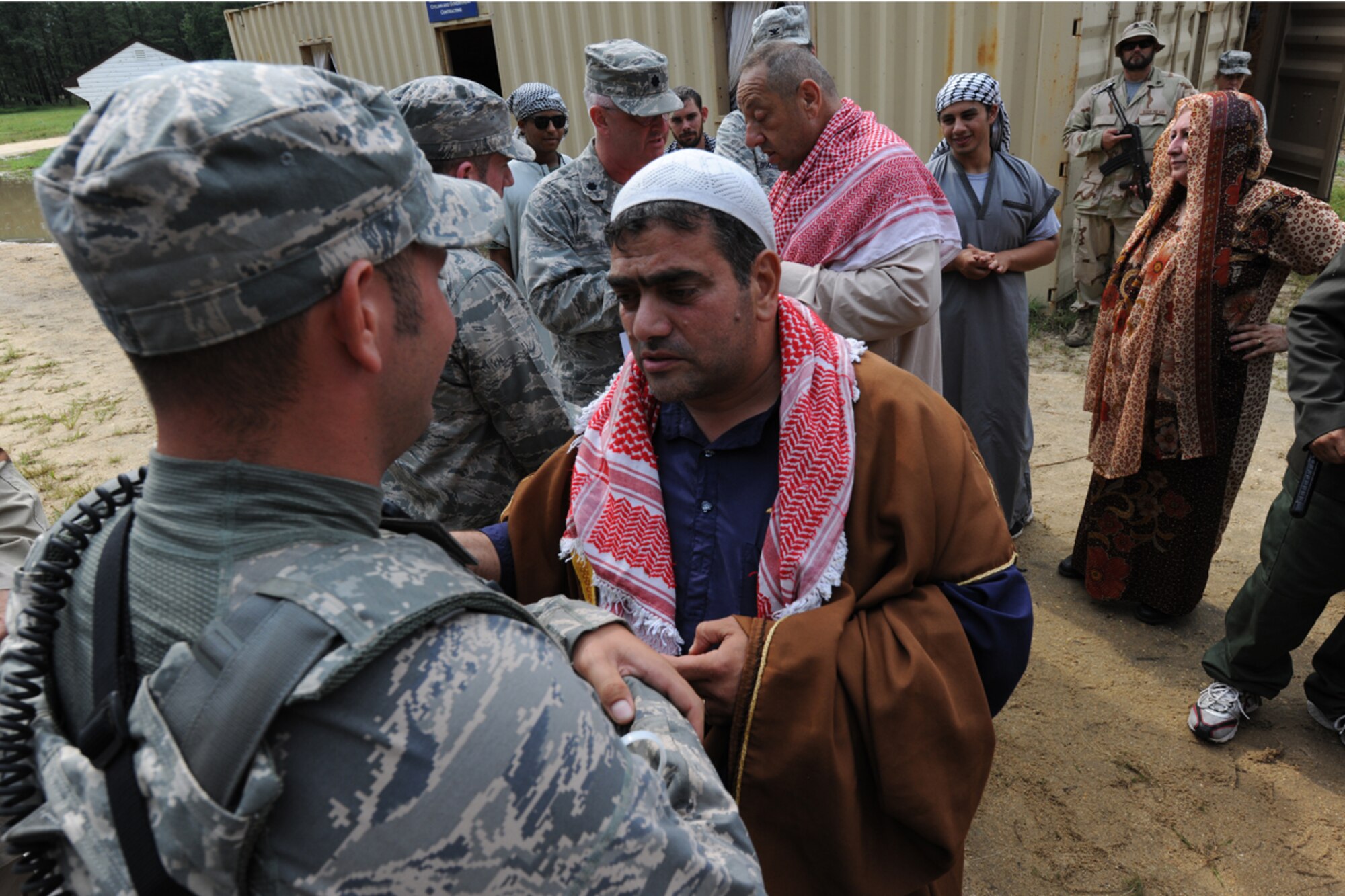 A contracted role player interacts with Security Forces members during their visit to the town of Sabor, part of the ficticious Kingdom of Nessor during Exercise Eagle Flag 12-4 Aug. 14th at Joint Base McGuire-Dix-Lakehurst, N.J. The Airmen are assigned to the 108th Contingency Response Group at JB M-D-L. The 108th joined forces with the U.S. Army’s 689th Rapid Port Opening Element from Fort Eustis, Va., to form a Joint Task Force Port Opening during Eagle Flag 12-4. (U.S. Air Force photo by Tech. Sgt. Zachary Wilson/Released)