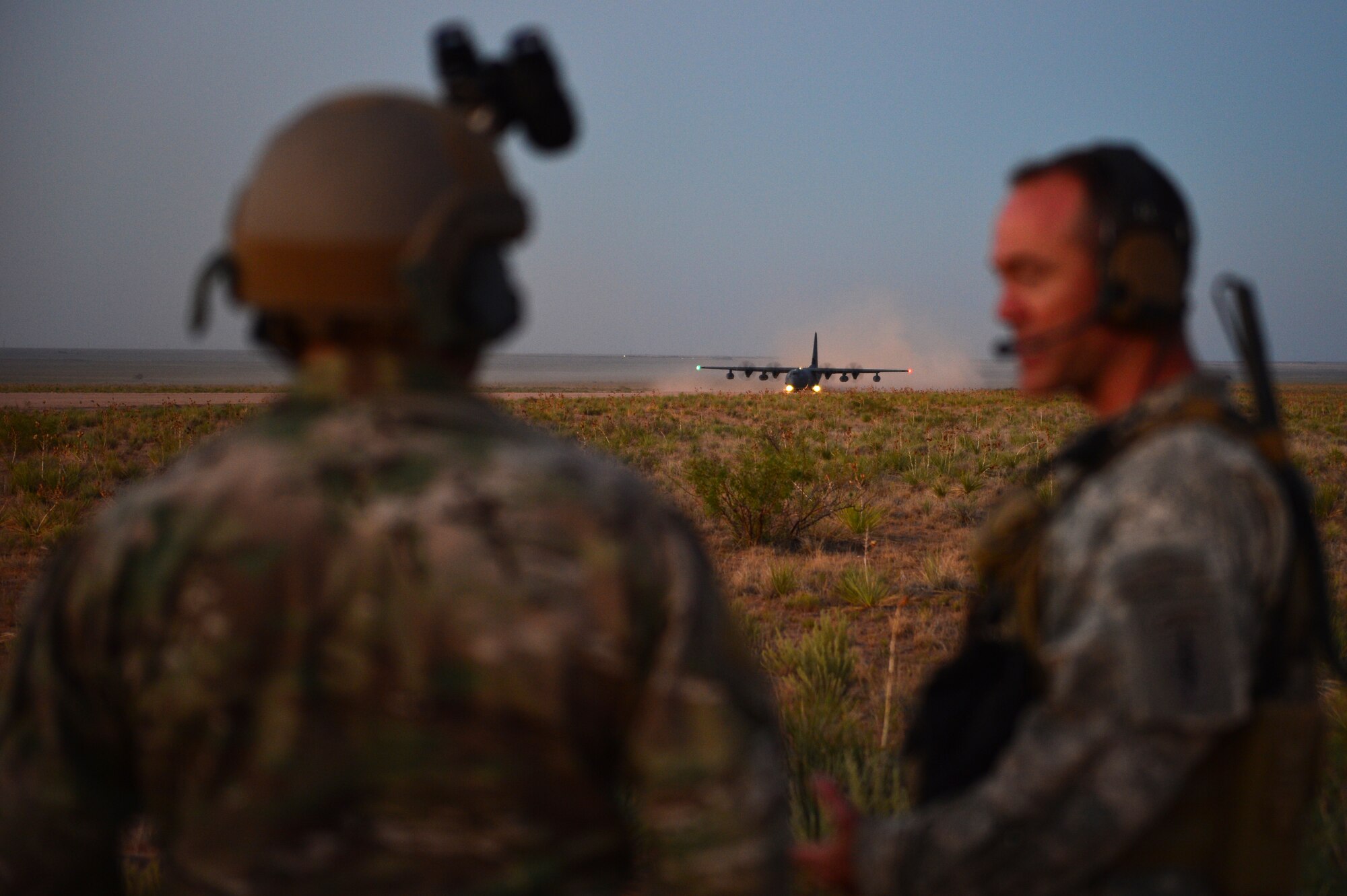 Soldiers with the 19th Special Forces Group talk while a C-130 prepares to take off in the distance at Melrose Air Force Range, N.M., Sept. 19, 2012. Melrose has been an integral part of Cannon Air Force Base, N.M., since the early 1950s. (U.S. Air Force photo/Airman 1st Class Eboni Reece)
