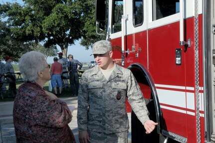 Airman 1st Class Kevin Lutker (right), 902nd Civil Engineer Squadron firefighter, explains fire emergency equipment to Gertie Wagner during the retiree appreciation event held at Joint Base San Antonio-Randolph, Texas, Sept. 22. The event is held annually at the Kendrick Club to educate the local retiree community on services available to them. (U.S. Air Force photo by Rich McFadden) 