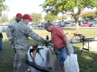 Tech. Sgt. Mark Fox (left), and Staff Sgt. Joshua Clements (center), 902nd Security Forces Squadron combat arms instructors, explain modern weaponry to Larry Wagner during the retiree appreciation event held at Joint Base San Antonio-Randolph, Texas, Sept. 22. The event is held annually at the Kendrick Club to educate the local retiree community on services available to them. (U.S. Air Force photo by Rich McFadden) 