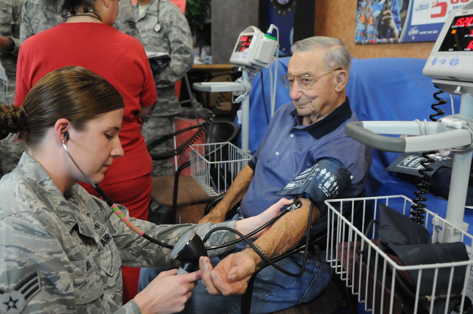 Senior Airman Kelly Boos (left), 359th Medical Operations Squadron medical technician, takes a blood pressure reading for Bill Jurczyn during the retiree appreciation event held at Joint Base San Antonio-Randolph, Texas, Sept. 22. The event is held annually at the Kendrick Club to educate the local retiree community on services available to them. (U.S. Air Force photo by Rich McFadden) 