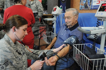 Senior Airman Kelly Boos (left), 359th Medical Operations Squadron medical technician, takes a blood pressure reading for Bill Jurczyn during the retiree appreciation event held at Joint Base San Antonio-Randolph, Texas, Sept. 22. The event is held annually at the Kendrick Club to educate the local retiree community on services available to them. (U.S. Air Force photo by Rich McFadden) 