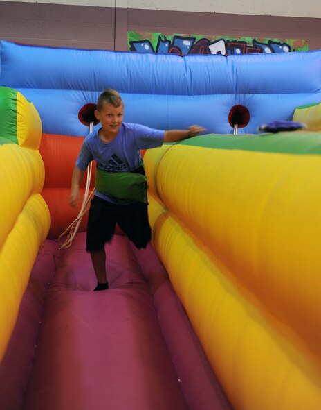 RAF MILDENHALL, England -- A boy tried to reach a bean bag while connected to a restraining belt during the  Worldwide Day of Play held at the RAF Mildenhall Youth Center Sept. 22, 2012. More than 900 people attended the Worldwide Day of Play which featured games, bouncy castles, Pets as Therapy dogs, go-karts and more. (U.S. Air Force photo/Tech. Sgt. Stacia Zachary)