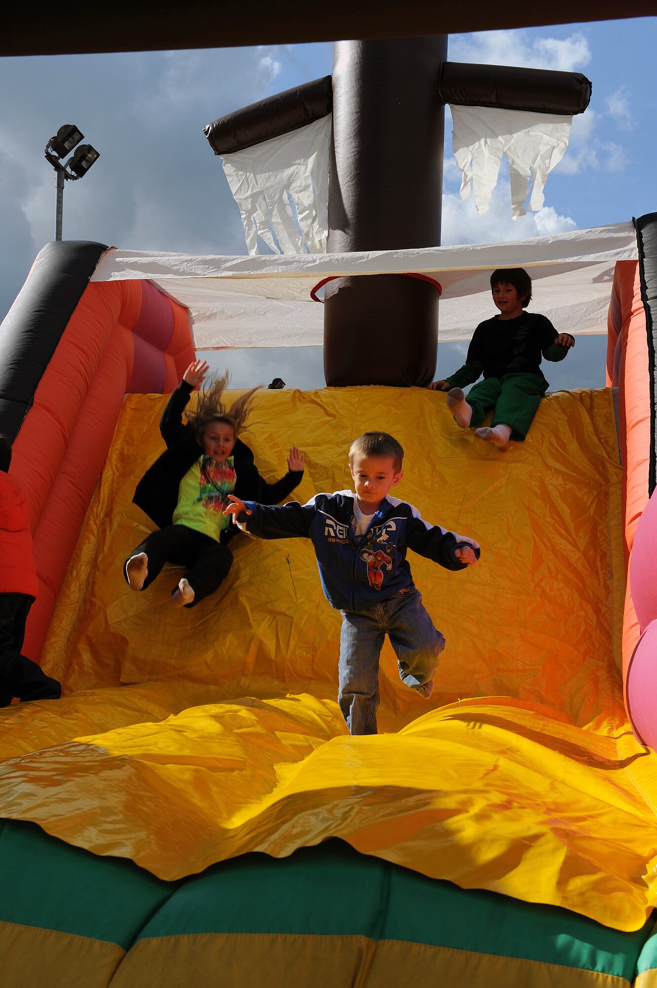 RAF MILDENHALL, England -- Children slide down the back end of a pirate bouncy castle during the Worldwide Day of Play held at the RAF Mildenhall Youth Center Sept. 22, 2012. More than 900 American and British people attended the Worldwide Day of Play which featured games, bouncy castles, Pets as Therapy dogs, go-karts and more. (U.S. Air Force photo/Tech. Sgt. Stacia Zachary)