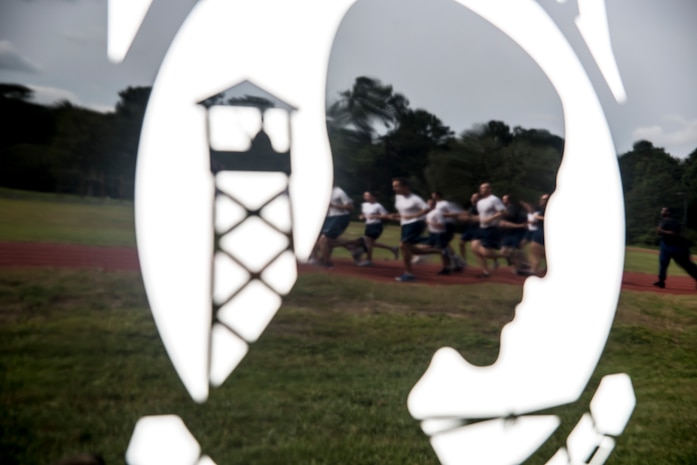 Airmen are seen running in a reflection of a Prisoner of War/Missing in Action emblem painted on the door of a car during the POW/MIA Run Sept. 20, 2012, at Joint Base Charleston – Air Base, S.C. Different units from the joint base carried the flag for 30 minutes each from 3:30 p.m. Sept. 20 to 3:30 p.m. Sept. 21 in honor of all POW’s and MIA’s. (U.S. Air Force photo/Staff Sgt. Rasheen Douglas)