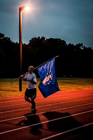 Staff Sgt. Justin Kyle, 437th Aircraft Maintenance Squadron, carries the United States Air Force flag during the Prisoner of War/Missing in Action Run Sept. 20, 2012, at Joint Base Charleston – Air Base, S.C. Service members carried their services flag around the track while other service members carried the POW/MIA flag from 3:30 p.m. Sept. 20 to 3:30 p.m. Sept. 21 in honor of all POWs and MIAs. (U.S. Air Force photo/Senior Airman Dennis Sloan) 