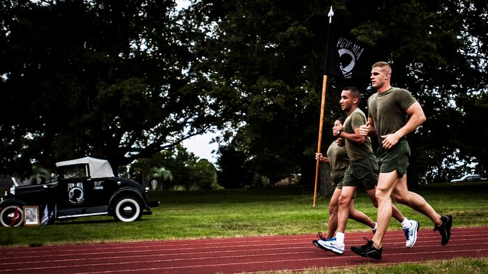 Marines from the Naval Consolidated Brig Charleston carry the Prisoner Of War/Missing in Action flag during the POW/MIA Run Sept. 20, 2012, at Joint Base Charleston – Air Base, S.C. Different units from the joint base carried the flag for 30 minutes each from 3:30 p.m. Sept. 20 to 3:30 p.m. Sept. 21 in honor of all POWs and MIAs. (U.S. Air Force photo/Senior Airman Dennis Sloan)