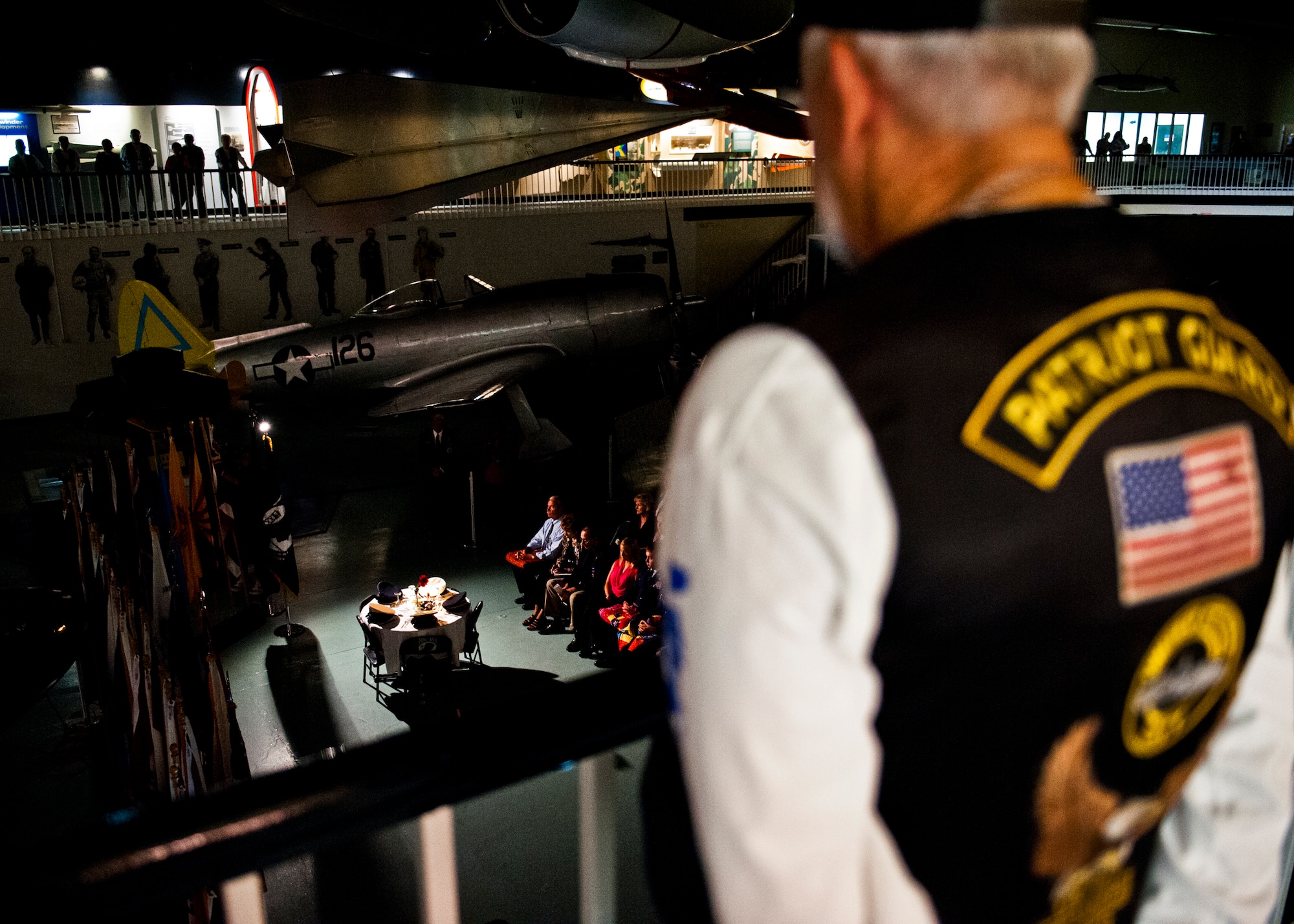 A Patriot Guard member watches the Prisoner-of-War, Missing-in-Action table setting during the POW/MIA event Sept 21 at the Air Force Armament Museum.  The ceremony paid tribute to those military members who have yet to return home from defending America. The event was hosted by the 53rd Wing and featured guest speakers, honor guard procedures and a flyover by the 85th Test and Evaluation Squadron.  (U.S. Air Force photo/Samuel King Jr.)