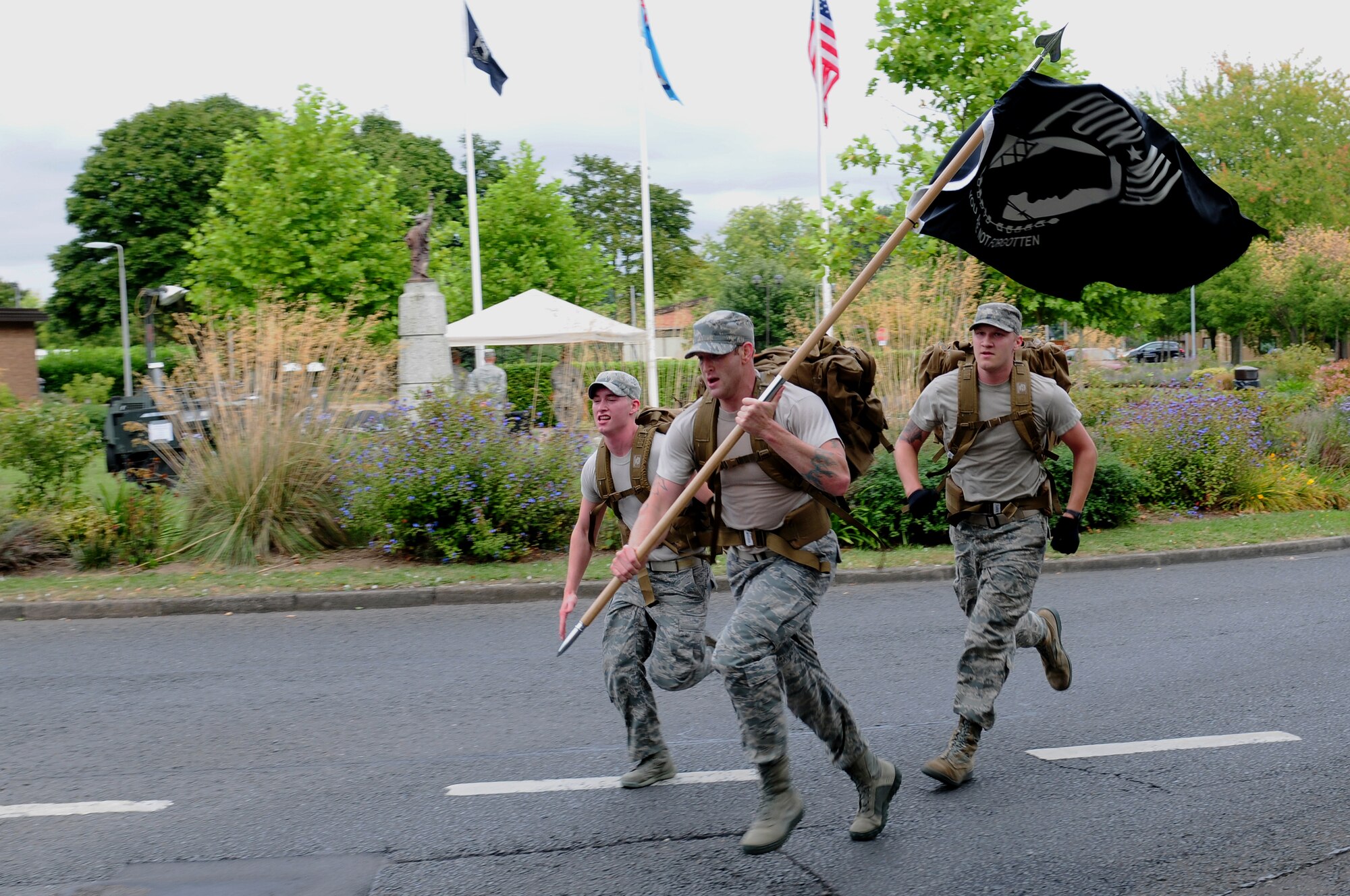 ROYAL AIR FORCE LAKENHEATH, England – (From left) Airman 1st Class Luke Bates, Senior Airman Joshua Nugent and A1C Ryan Praleikas, 48th Medical Operations Squadron medical technicians, run to the finish line during the POW/MIA ruck march Sept. 21, 2012. The theme of this year’s POW/MIA Remembrance week is “Never Forgotten,” referring to the hardships and sacrifices former POWs made and serving as a reminder of those who are still missing. (U.S. Air Force photo by Airman 1st Class Cory D. Payne)
