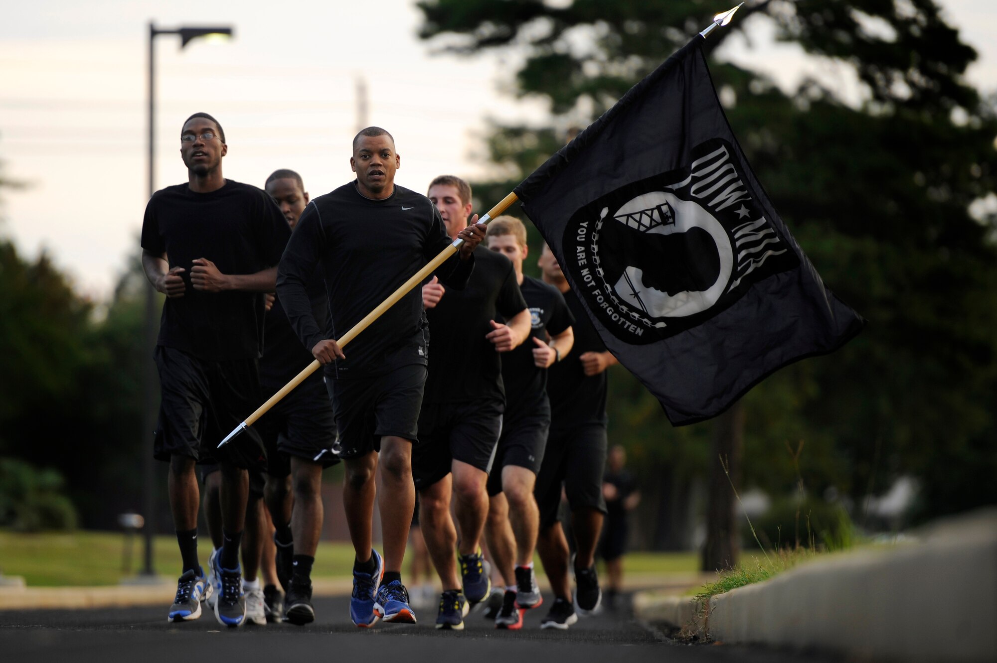 U.S. Air Force Master Sgt. Cohen Young, 20th Fighter Wing Public Affairs superintendent, leads a group of 20th Comptroller Squadron Airmen as he carries the Prisoner of War/Missing in Action flag during a POW/MIA 24-hour remembrance run, Sept. 20, 2012, Shaw Air Force Base, S.C. Team Shaw Airmen from several different units participated in the 24-hour run in honor of those service men and women who are and where POW or MIA. (U.S. Air Force photo by Senior Airman Kenny Holston/Released)
