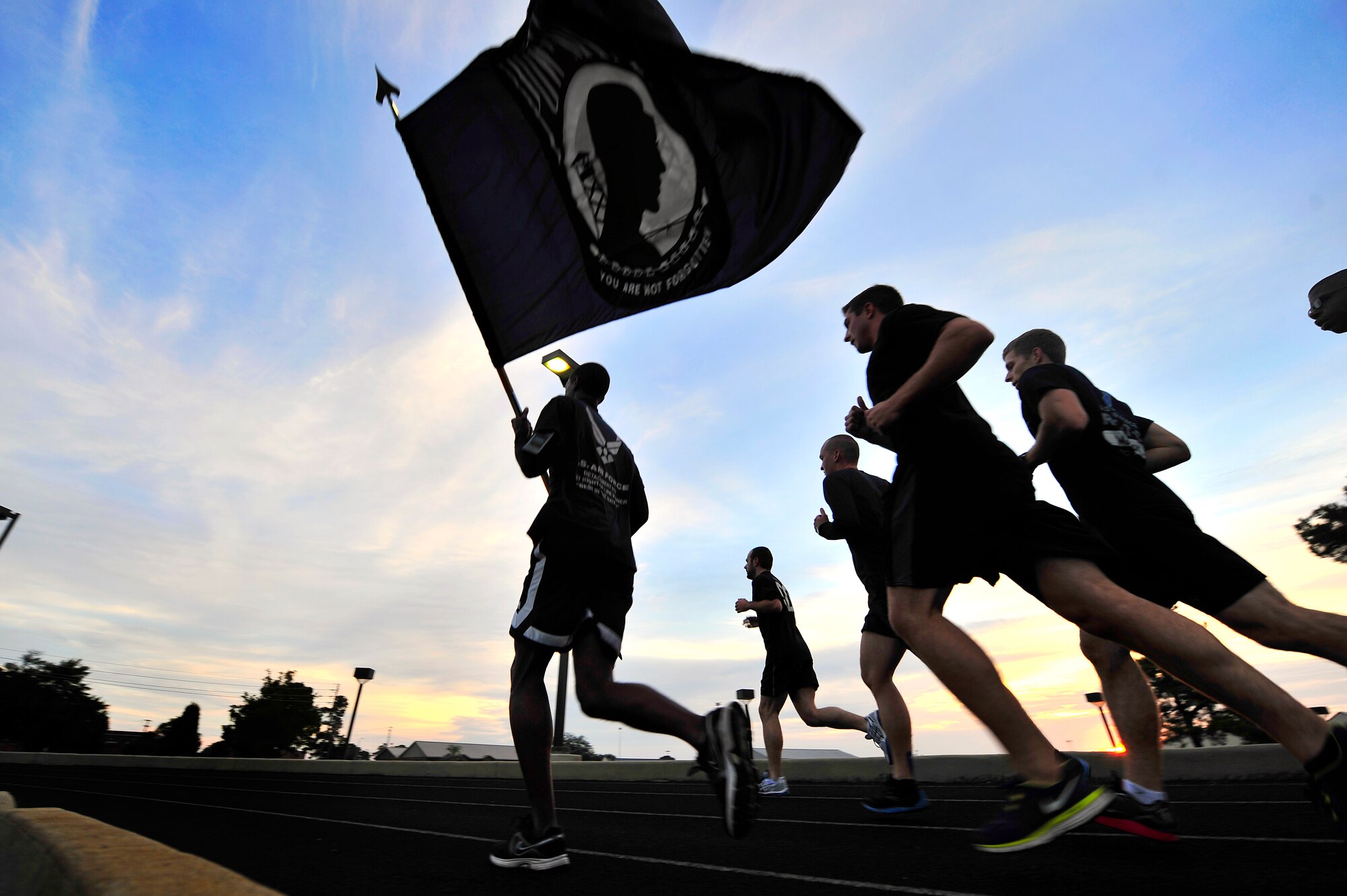 U.S. Air Force 2nd Lt. Earon Brown, 20th Fighter Wing Public Affairs operations officer, leads a group of 20th Comptroller Squadron Airmen as he carries the Prisoner of War/Missing in Action flag during a POW/MIA 24- hour remembrance run, Sept. 20, 2012, Shaw Air Force Base, S.C. Team Shaw Airmen from several different units participated in the 24-hour run in honor of those service men and women who are and were POW/ MIA. (U.S. Air Force photo by Senior Airman Kenny Holston/Released)
