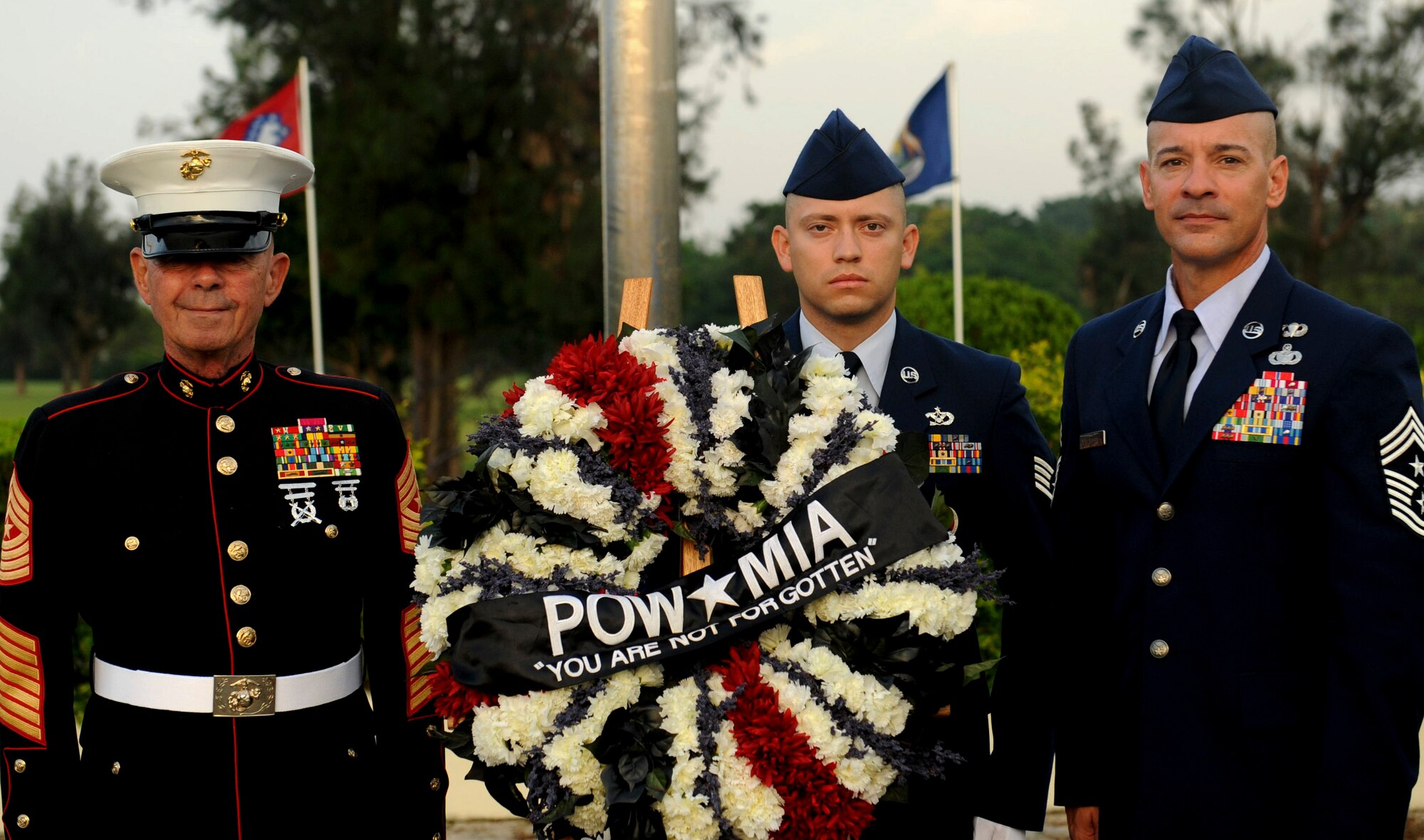 U.S. Marine Corps retired Sgt. Maj. Peter M. Gorczewski, U.S. Air Force Staff Sgt. Julio Rivera, Civil Engineering Squadron NCO in charge generator maintenance, and Chief Master Sgt. Mark Marson, 18th Wing command chief, stand with the Prisoners of War/Missing in Action wreath during a POW/MIA flag ceremony on Kadena Air Base, Japan, Sept. 21, 2012. It is important to always remember those who have served and have yet to return home and the families that still wait for them. (U.S. Air Force photo/Airman 1st Class Hailey Davis)       