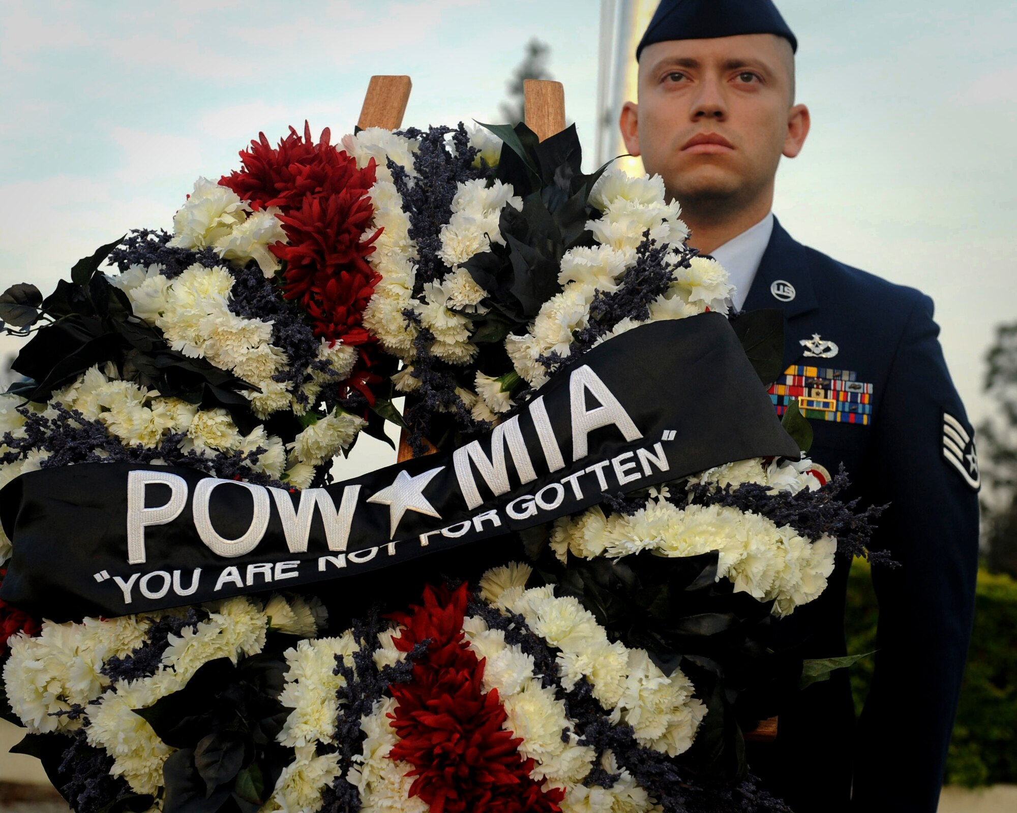 U.S. Air Force Staff Sgt. Julio Rivera, 18th Civil Engineering Squadron NCO in charge of generator maintenance, stands behind the Prisoners of War/Missing in Action wreath during a POW/MIA flag ceremony on Kadena Air Base, Japan, Sept. 21, 2012. The National POW/MIA Recognition Day is observed on the third Friday of September every year, but it is important to remember POWs and service members who remain MIA. (U.S. Air Force photo/Airman 1st Class Hailey Davis)     