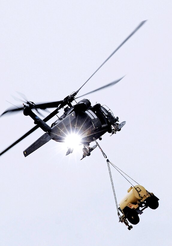 A UH-60L Black Hawk helicopter carries a water trailer away during sling-load operations on Joint Base Elmendorf-Richardson, Alaska, Sept. 20, 2012.