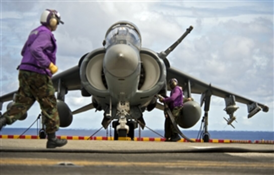 A flight deck crewman refuels an AV-8B Harrier jet aircraft on the flight deck of the amphibious assault ship USS Bonhomme Richard (LHD 6) during flight operations in the Philippine Sea on Sept. 20, 2012.  The Harrier is assigned to Marine Attack Squadron 542.  