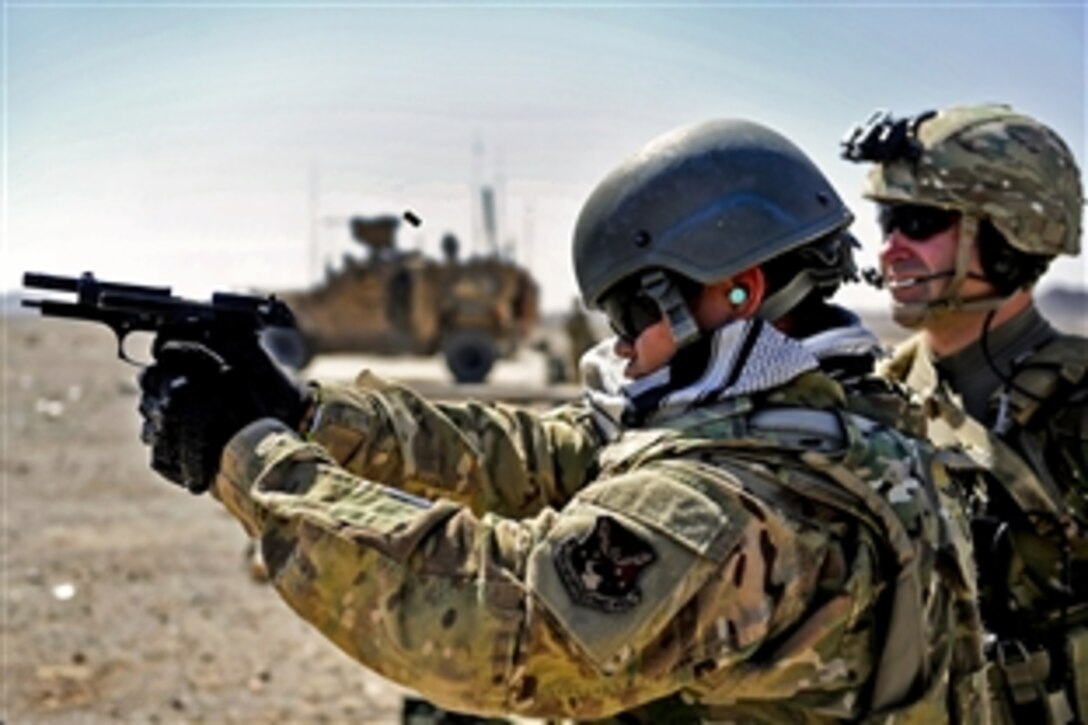 U.S. Army Pvt. Dean Michael, right, trains U.S. Air Force Senior Airman Robert Ignacio, left, on the loading procedures for an M-240B machine gun on Forward Operating Base Farah in Afghanistan's Farah province, Sept. 22, 2012. Michael and Ignacio are assigned to Provincial Reconstruction Team Farah.