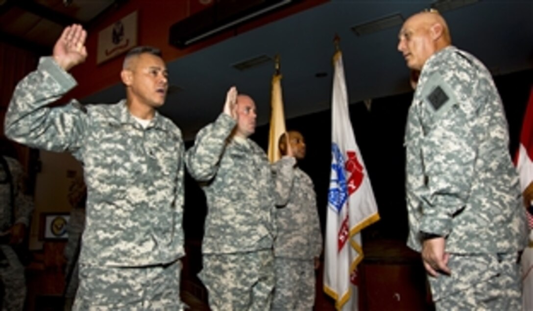 U.S. Army Chief of Staff Gen. Ray Odierno re-enlists U.S. Army Sgts. Joe Avent, far left, and David Tinsley, team leaders, and Staff Sgt. Curtis Berry, administration sergeant, on Camp Lemonnier, Djibouti, Sept. 20, 2012. The soldiers are assigned to the 702nd Military Police Company.