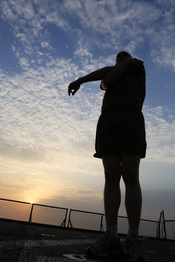 USS GUNSTON HALL, Gulf of Aden, (Sept. 15, 2012) - A Marine corporal with the 24th Marine Expeditionary Unit stretches before conducting morning physical training on the flight deck of the USS Gunston Hall in the Gulf of Aden, Sept. 15, 2012. The PT was part of a command-sponsored Corporal's Course that took place both ashore in Kuwait and aboard the ship. The 24th MEU is deployed with the Iwo Jima Amphibious Ready Group as a theater reserve force for U.S. Central Command and is providing support for maritime security operations and theater security cooperation efforts in the U.S. Navy's 5th Fleet area of responsibility. (Official Marine Corps photo by Sgt. Richard Blumenstein)
