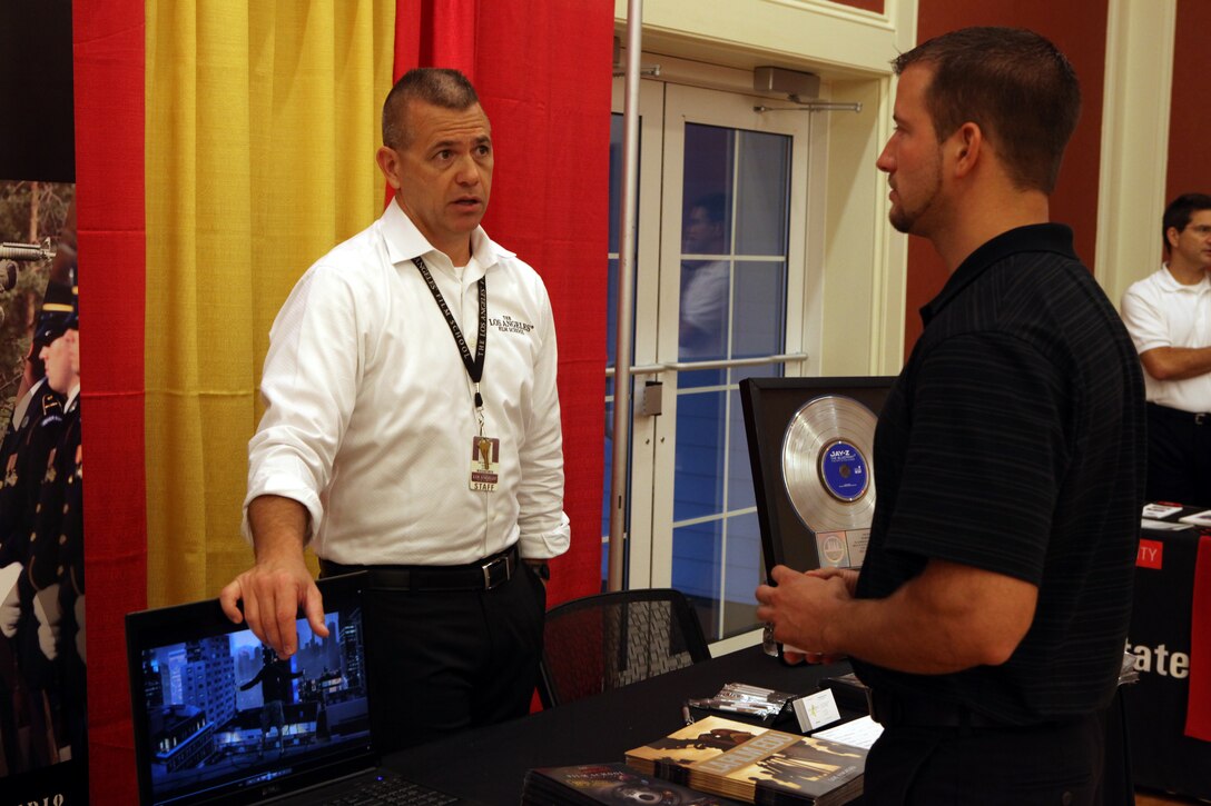 A representative from the Los Angeles Film School explains the classes the school offers to an interested participant in the Job Fair and Education Exposition aboard Marine Corps Base Camp Lejeune Sept. 19. Approximately 55 different schools were present for service members and dependents to explore their future options post-military.