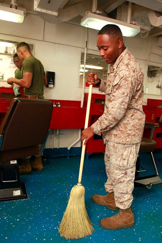 Corporal Tevin C. Ammons, police sergeant, and Cpl. Steve W. Nelson, utilities maintenance chief, both with the Command Element, 15th Marine Expeditionary Unit, conduct a field day in the troop barbershop, aboard the USS Peleliu, Sept. 23. The 15th MEU is currently embarked as part of the Peleliu Amphibious Ready Group, while they serve as the nation's rapid-response sea-based Marine Air Ground Task Force for Western Pacific Deployment 12-02. Ammons, 22, is from Lorain, Ohio, and Nelson, 23, is from Eagan, Minn. 