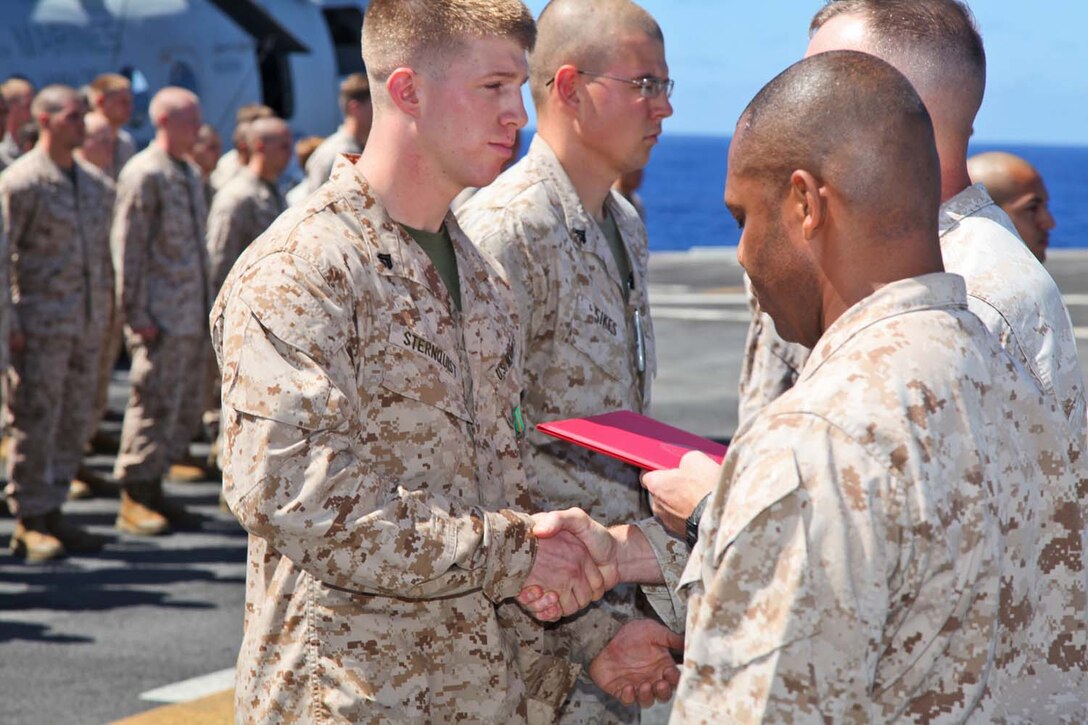 Corporal Matthew T. Sternquist, radio operator, Command Element, 15th Marine Expeditionary Unit, is presented the Navy Marine Corps Achievement Medal during an award ceremony on the flight deck of the USS Peleliu, Sept 23.  The MEU is currently embarked about the Peleliu Amphibious Ready Group for a Western Pacific deployment. Sternquist ,22, is from Bourbonnais, Ill.