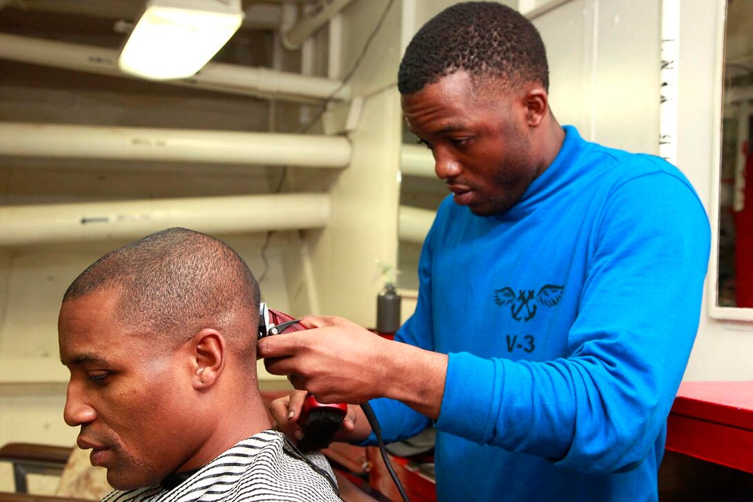 Petty Officer 3rd Class Sadi L. Brown, aviation boatswain’s mate handling, USS Peleliu, gives Gunnery Sgt. Corey O. Wright, food service chief, 15th Marine Expeditionary Unit, a haircut in the troop barbershop, aboard the USS Peleliu, Sept. 23. The 15th MEU is currently embarked as part of the Peleliu Amphibious Ready Group, while they serve as the nation's rapid-response sea-based Marine Air Ground Task Force for Western Pacific Deployment 12-02. Brown, 24, is from Americas, Ga., and Wright, 37, is from Xenia, Ohio. 