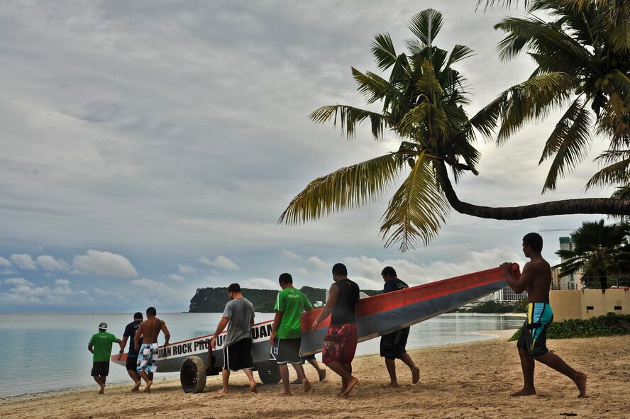 TAMUNING, Guam—Crew members from different team help each other bring out their boats prior to the 2012 Second Annual 9/11 Commemorative Dragon Boat Race at Matapang Beach here, Sept. 22. This year’s boat race had ten-person teams that included personnel from the Guam Police Department, Andersen Air Force Base, deployed-in Kadena AFB Fire department, Guam Fire Department, Guam National Guard, Naval Fire Department, Navy Tag Five and the Haggan Outrigger Canoe Club. The dragon boat race consisted of eight separate heats, competing for time. The Guam Police Department took the overall win with 2:12.63 seconds. (U.S. Air Force photo by Staff Sgt. Alexandre Montes/Released)